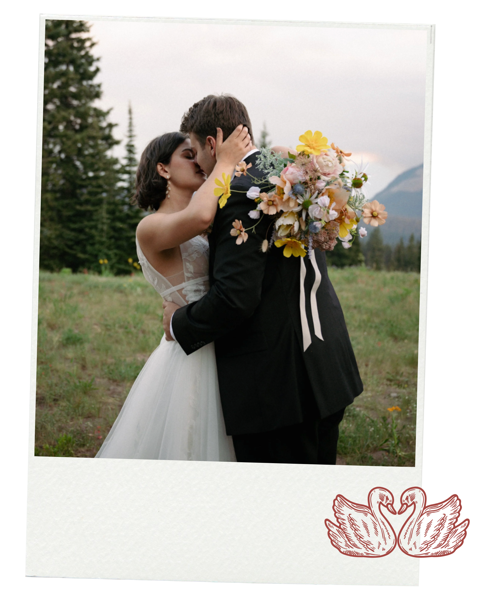A bride and groom kissing at their elopement in Crested Butte, Colorado. They are surrounded by wildflowers with mountains in the background.