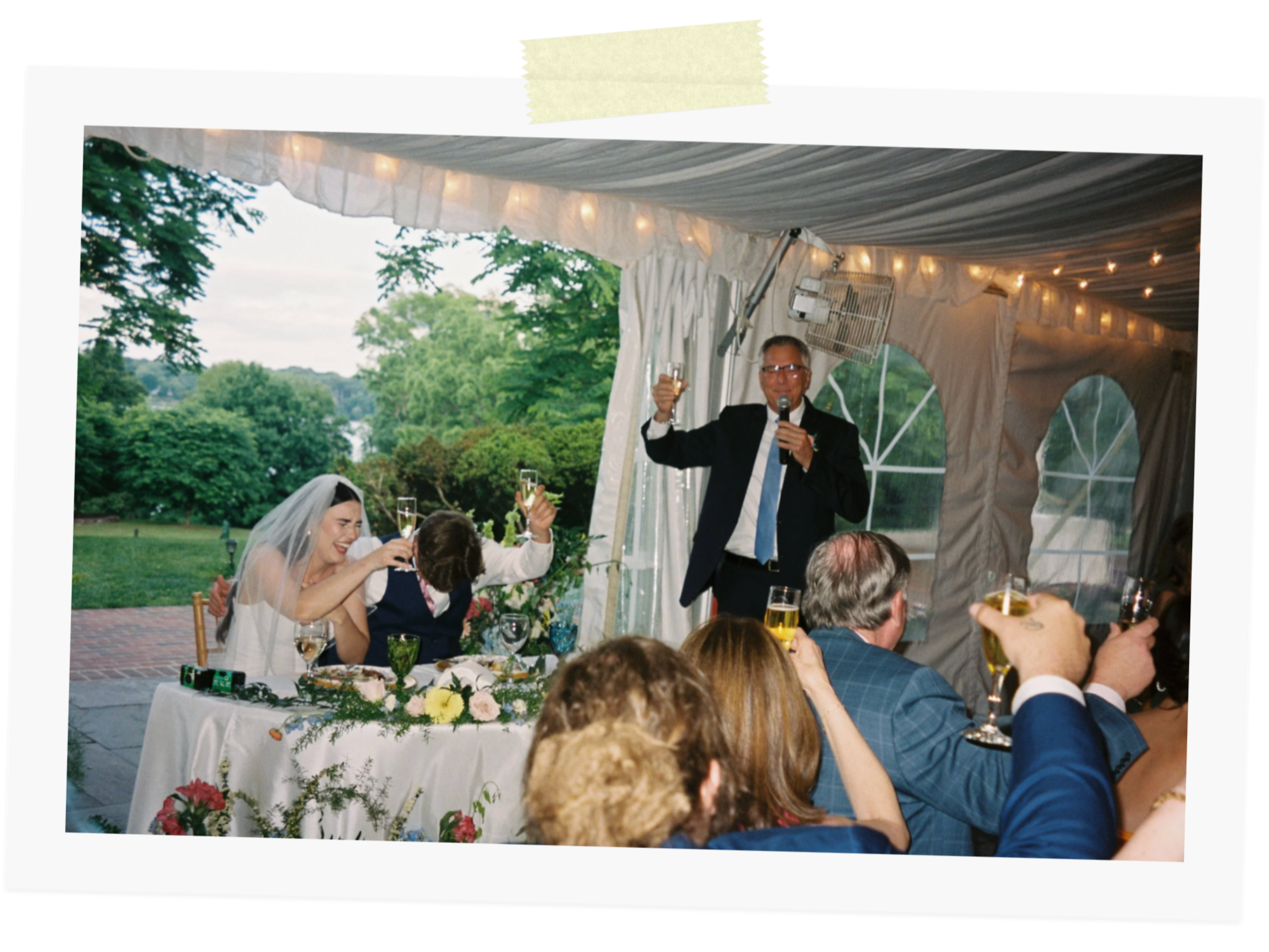 The bride and groom laughing at her dad's toast. The image was captured on 35mm film at a wedding in Alexandria, Virginia.