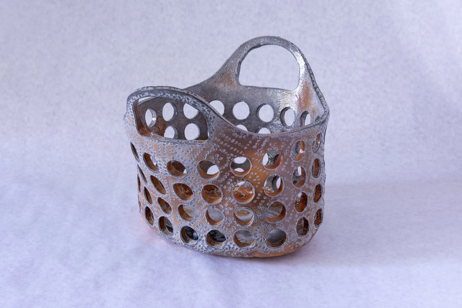 Small Oval Slotted Basket with Handles (Bauer Orange), 2026, soda fired porcelain, 10" x 11" x 11"