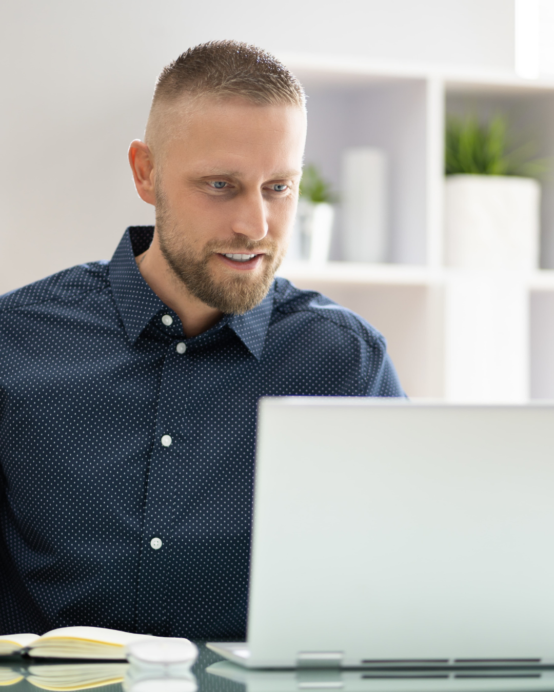 Male tech founder studying investor pitch playbook on laptop