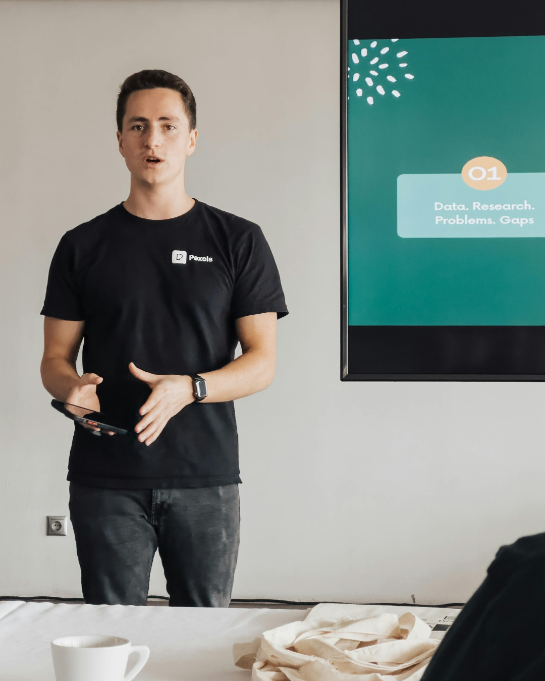 Startup founder practicing investor pitch delivery in front of team in office