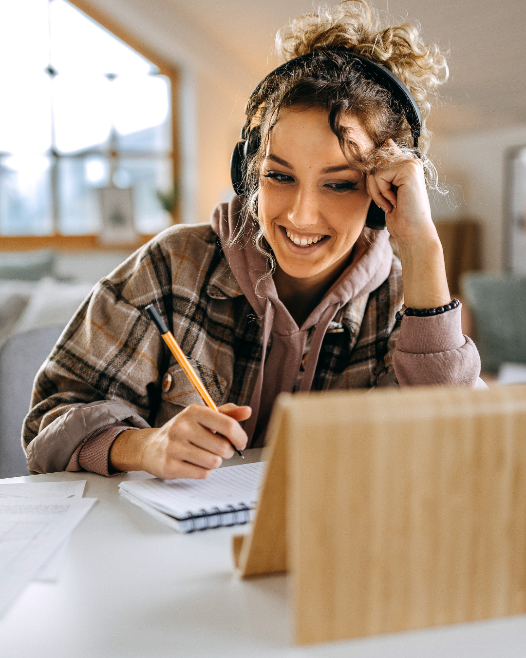 Female founder on video call coaching session taking notes