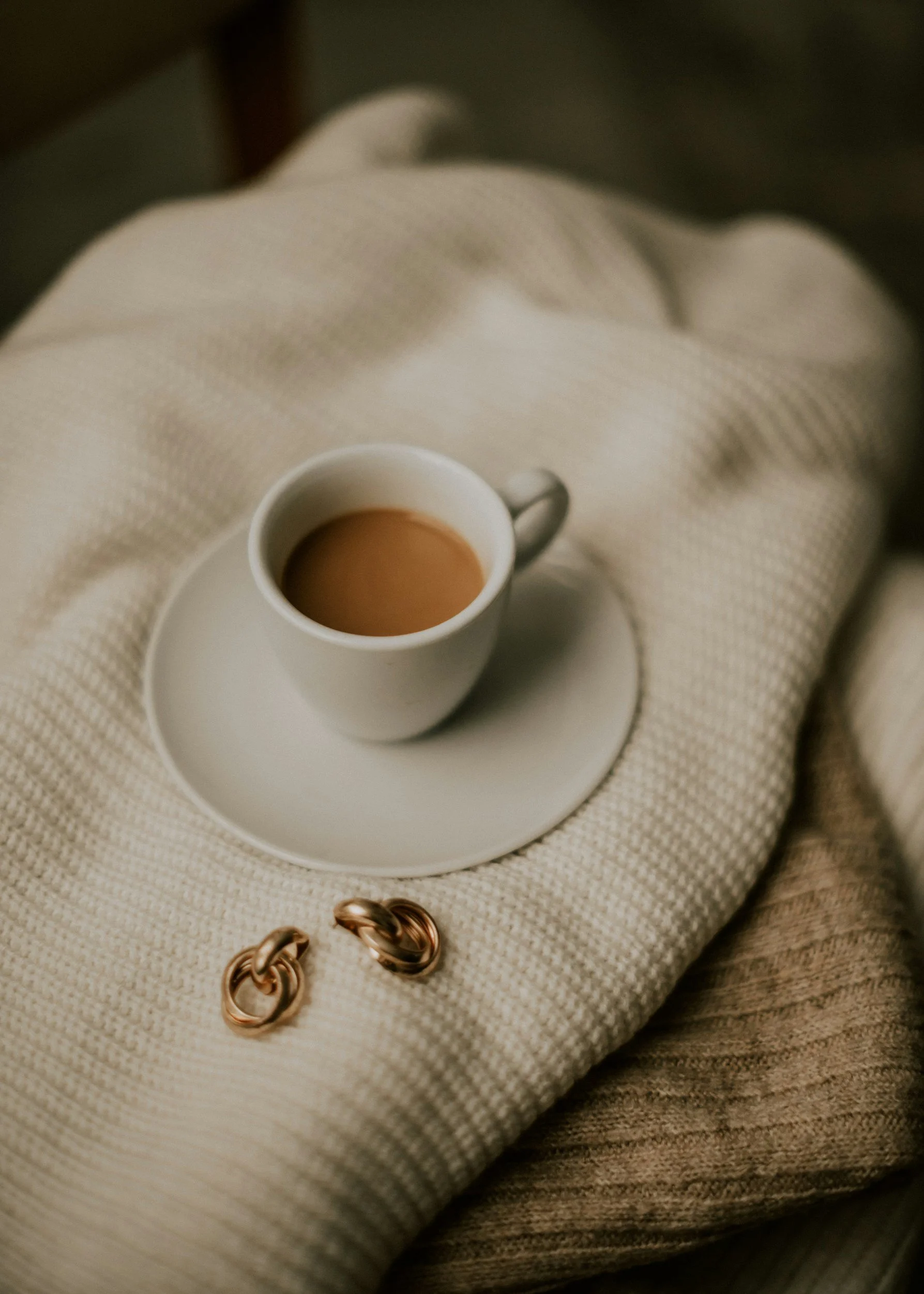 coffee, blanket, plate, mug, coffee cup, beige, brown, gold, sweater, blanket, earrings
