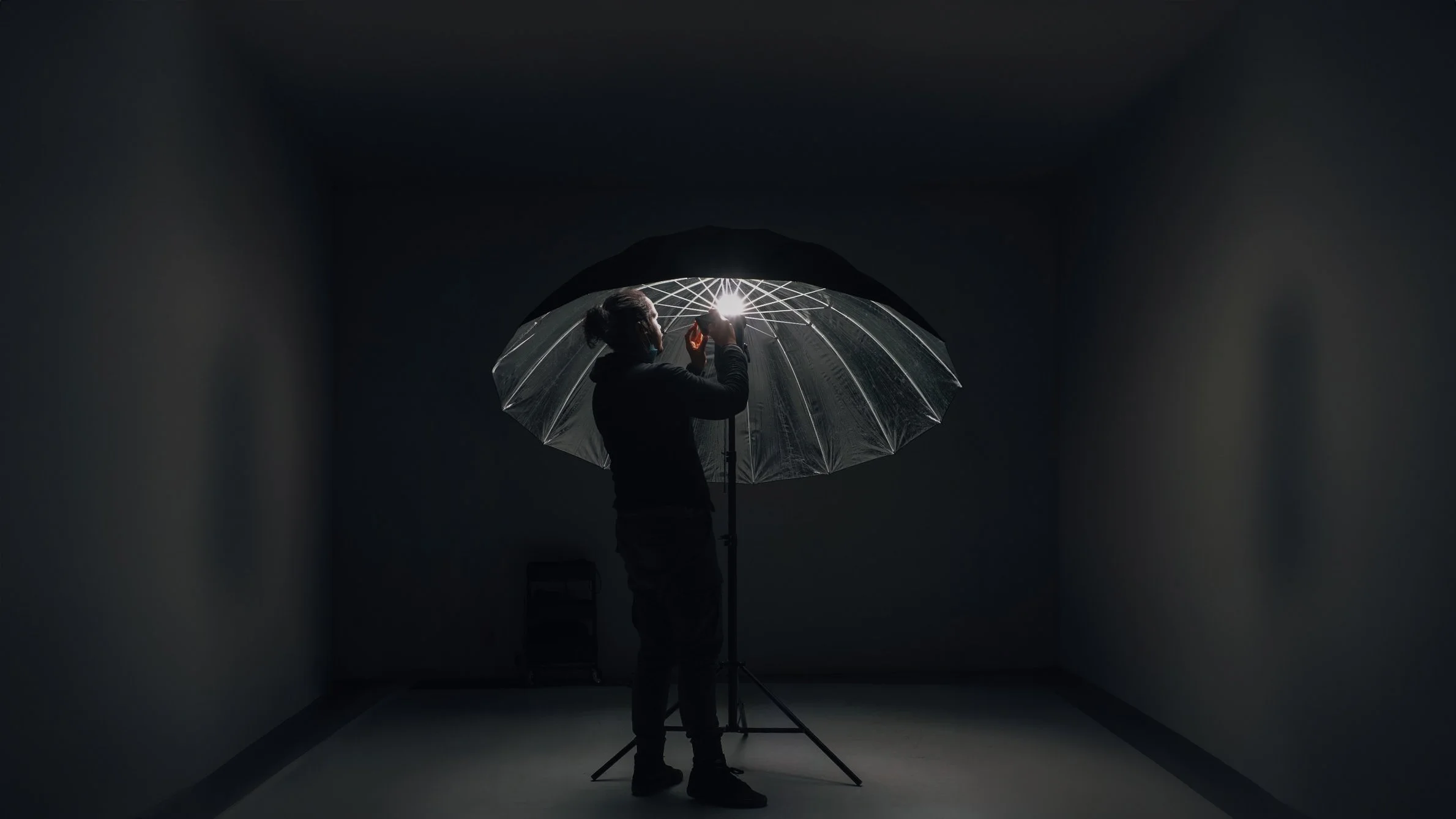 Nouf Yarub in the studio beside a lit umbrella