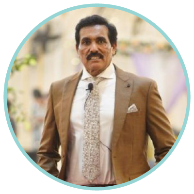 A woman and a man smiling in a professional setting with flags and a whiteboard in the background.