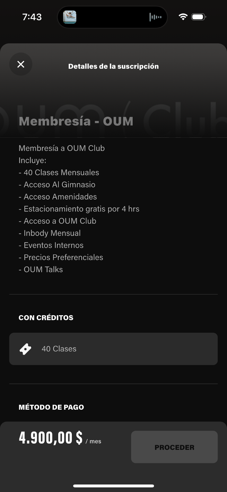 Pantalla de un teléfono móvil mostrando detalles de una suscripción al club OUM, que incluye clases mensuales, acceso al gimnasio, áreas comunes, estacionamiento gratis, eventos internos, precios preferenciales y acceso a conversaciones de OUM.