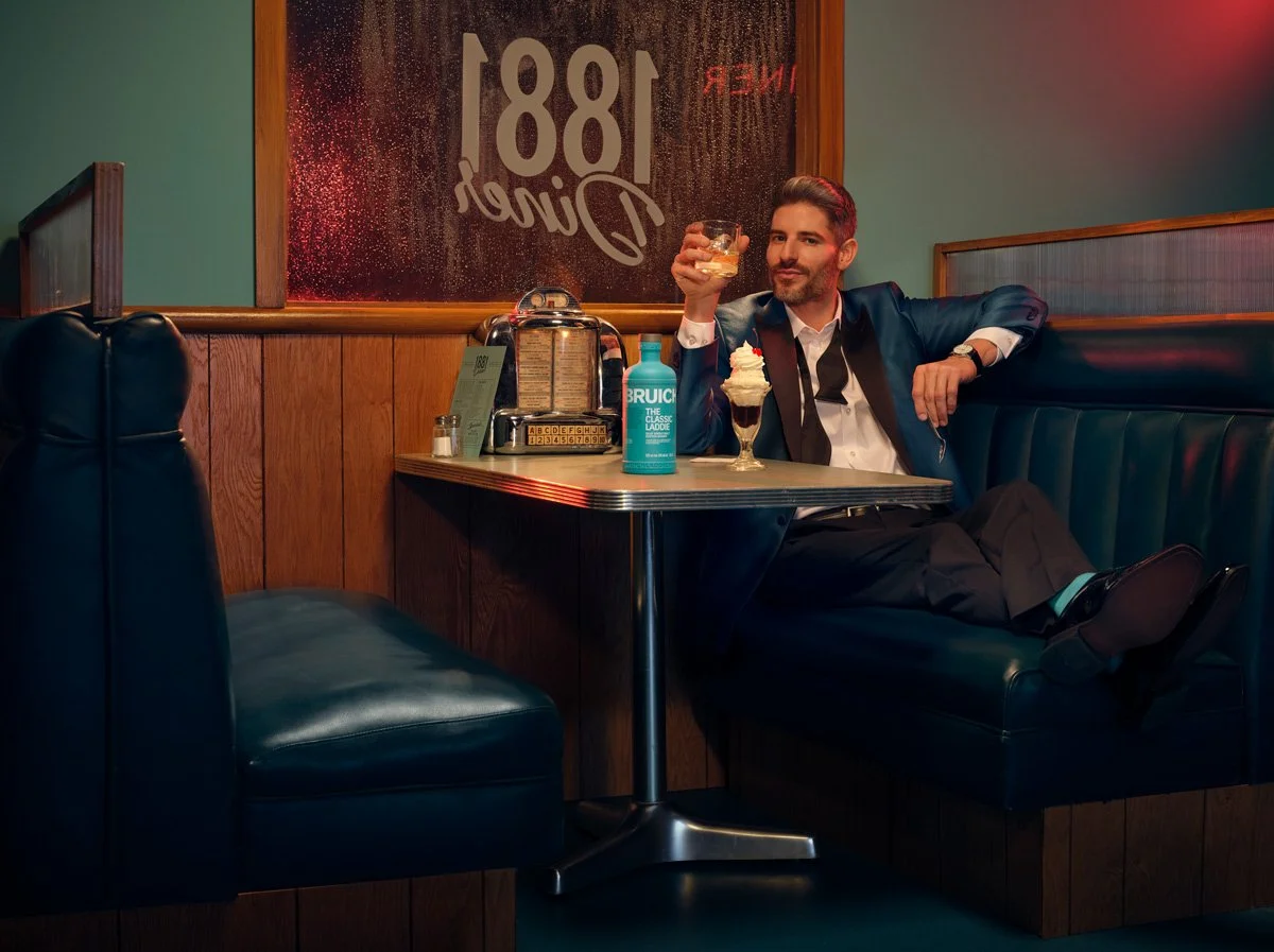 A gentleman in a fancy suite enjoying scotch and an ice cream sundae. This scene was styled by David Probasco. 