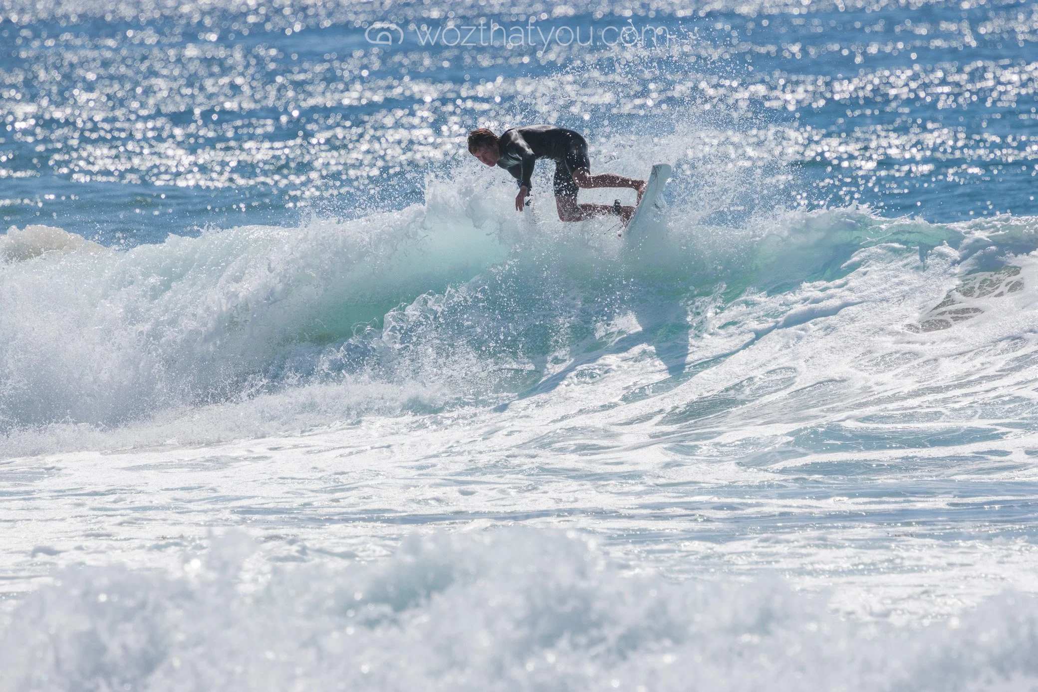 A person surfing on a wave at the beach during daytime.