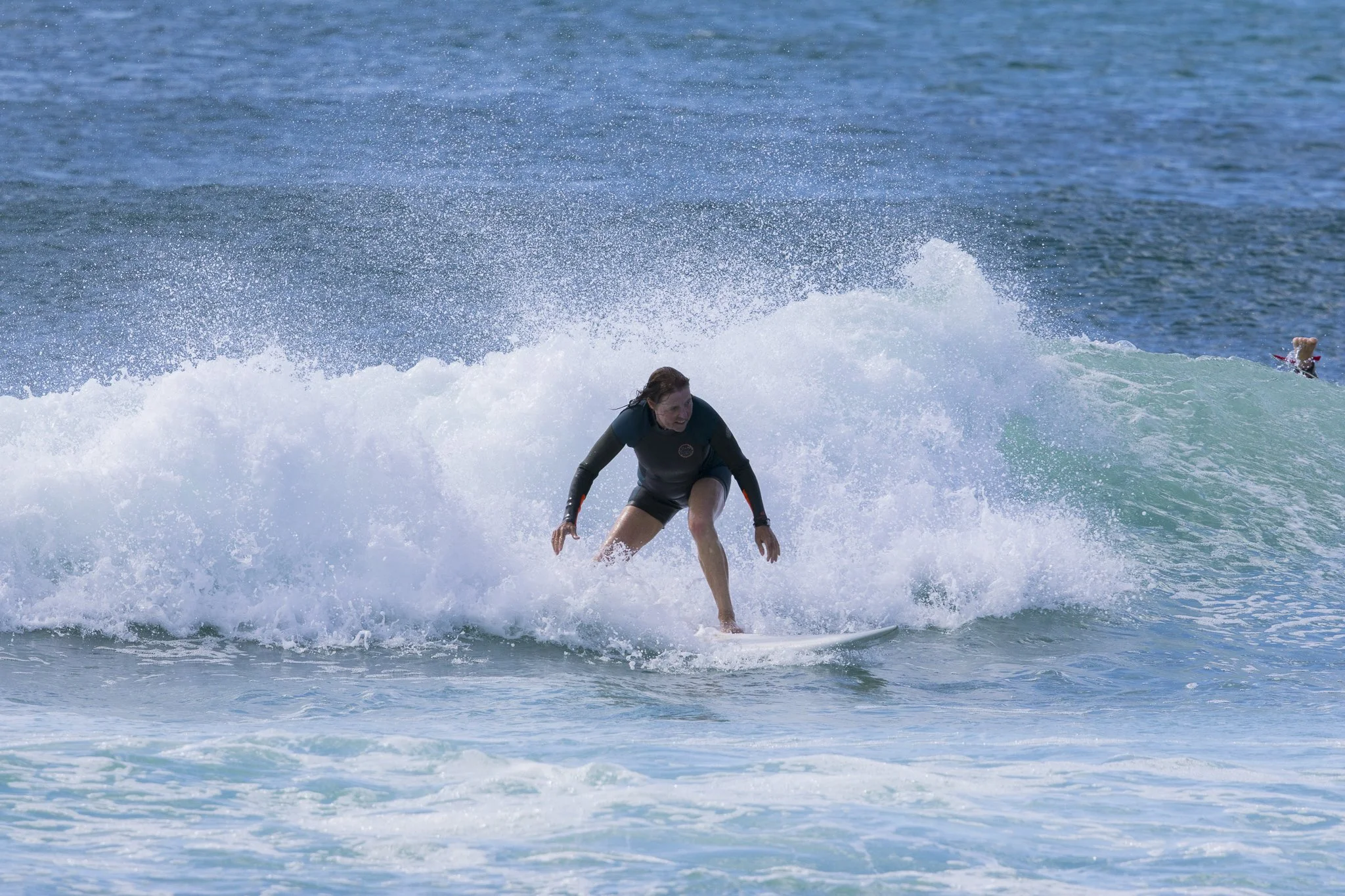A woman surfing on a wave in the ocean.