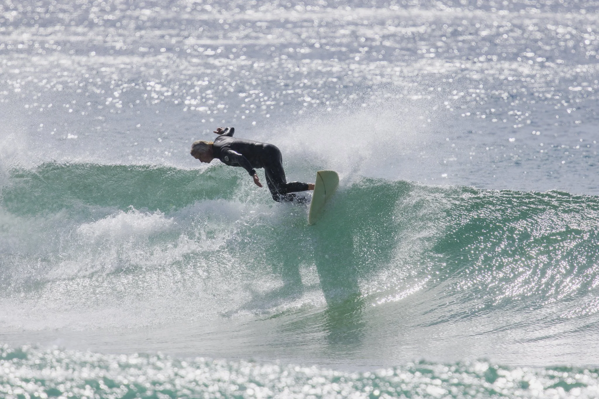 A person surfing on a wave in the ocean during the daytime.
