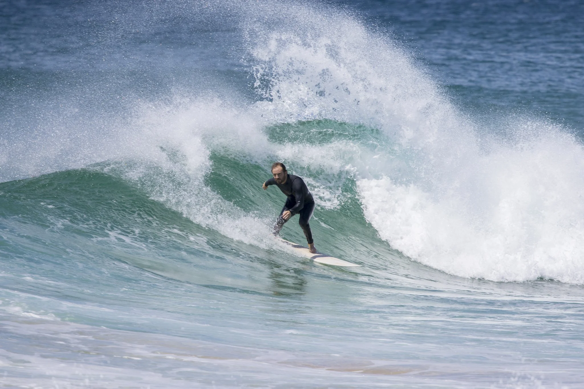 A man surfing on a wave in the ocean.