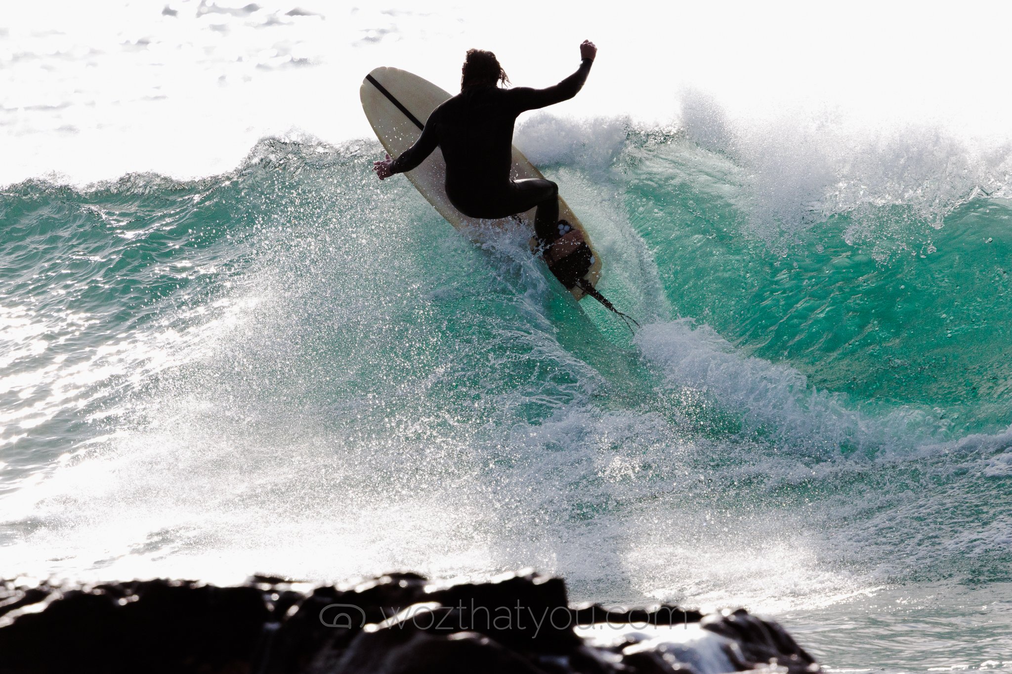 A person surfing on a wave in the ocean during the daytime.