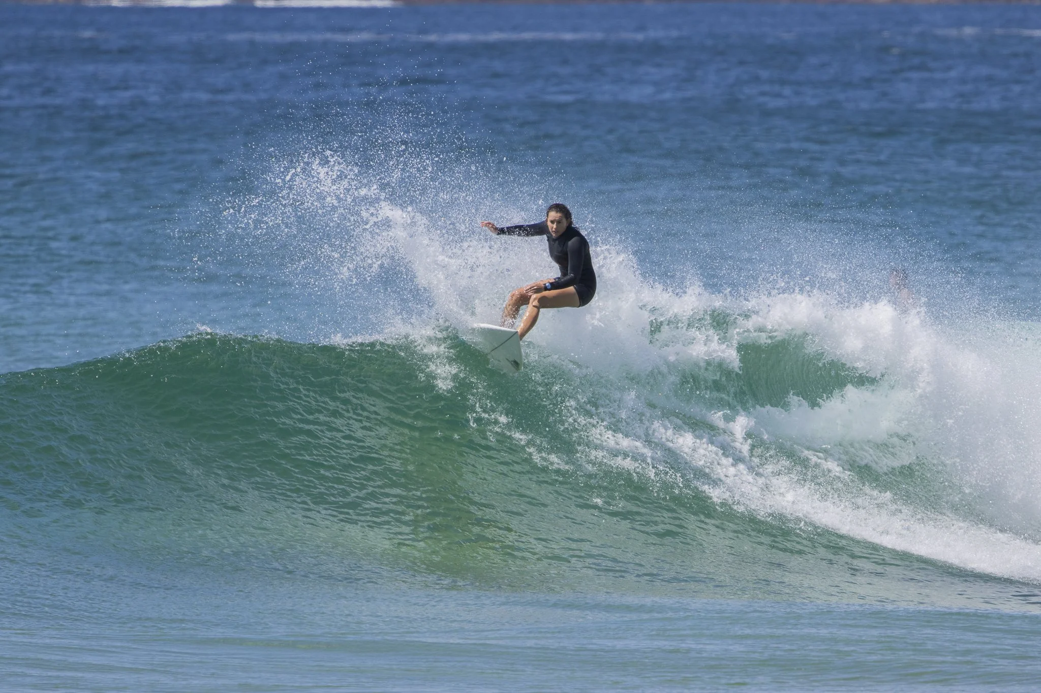 A woman surfing on a wave in the ocean.