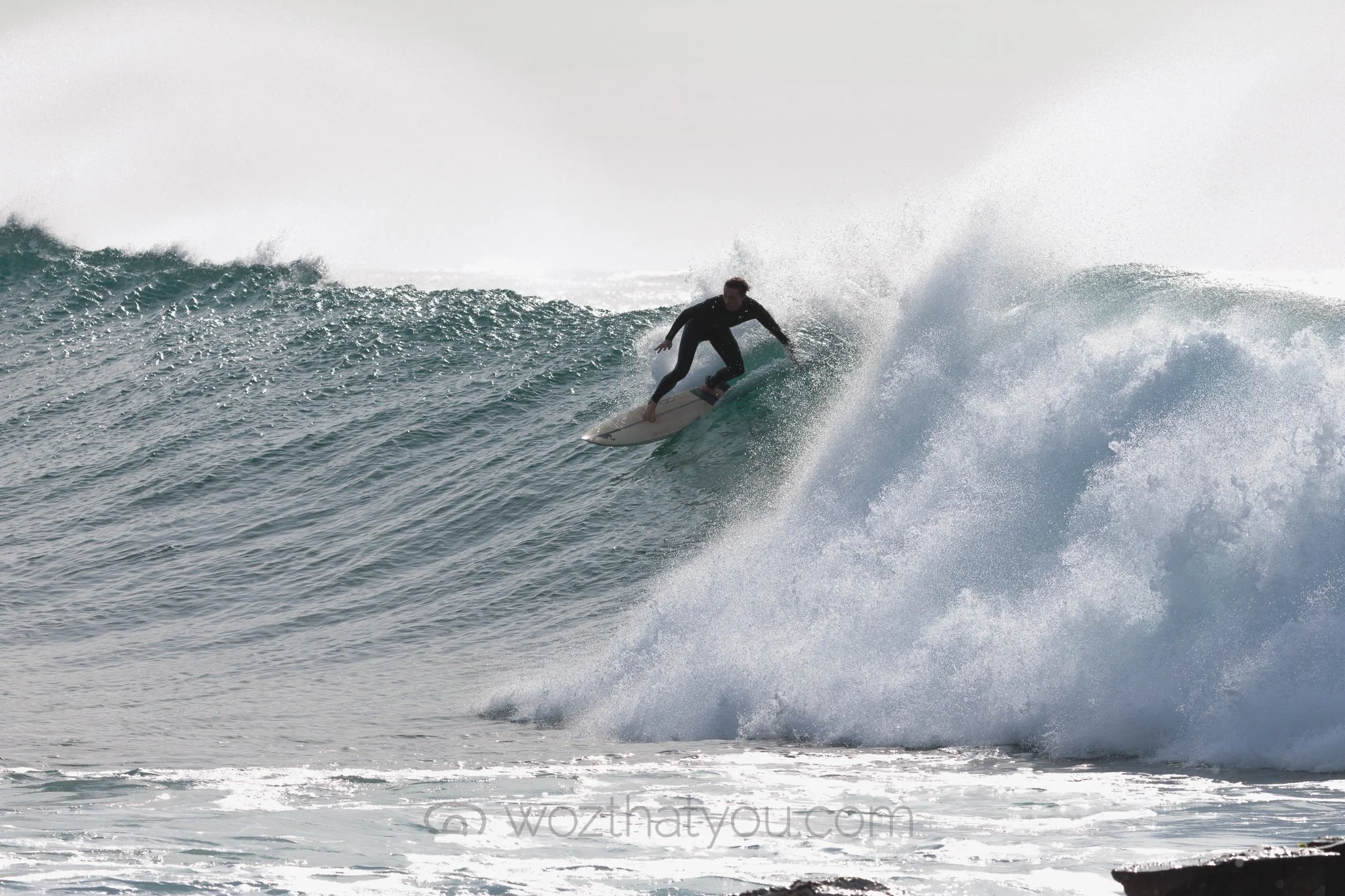 A surfer riding a wave in the ocean.