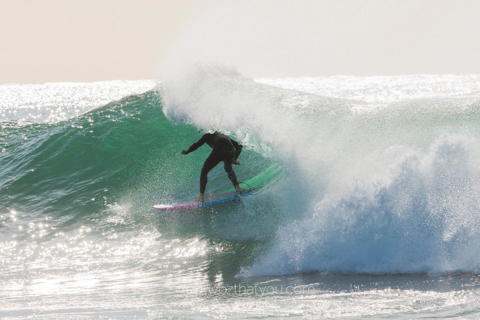 A person surfing on a wave in the ocean during daylight.