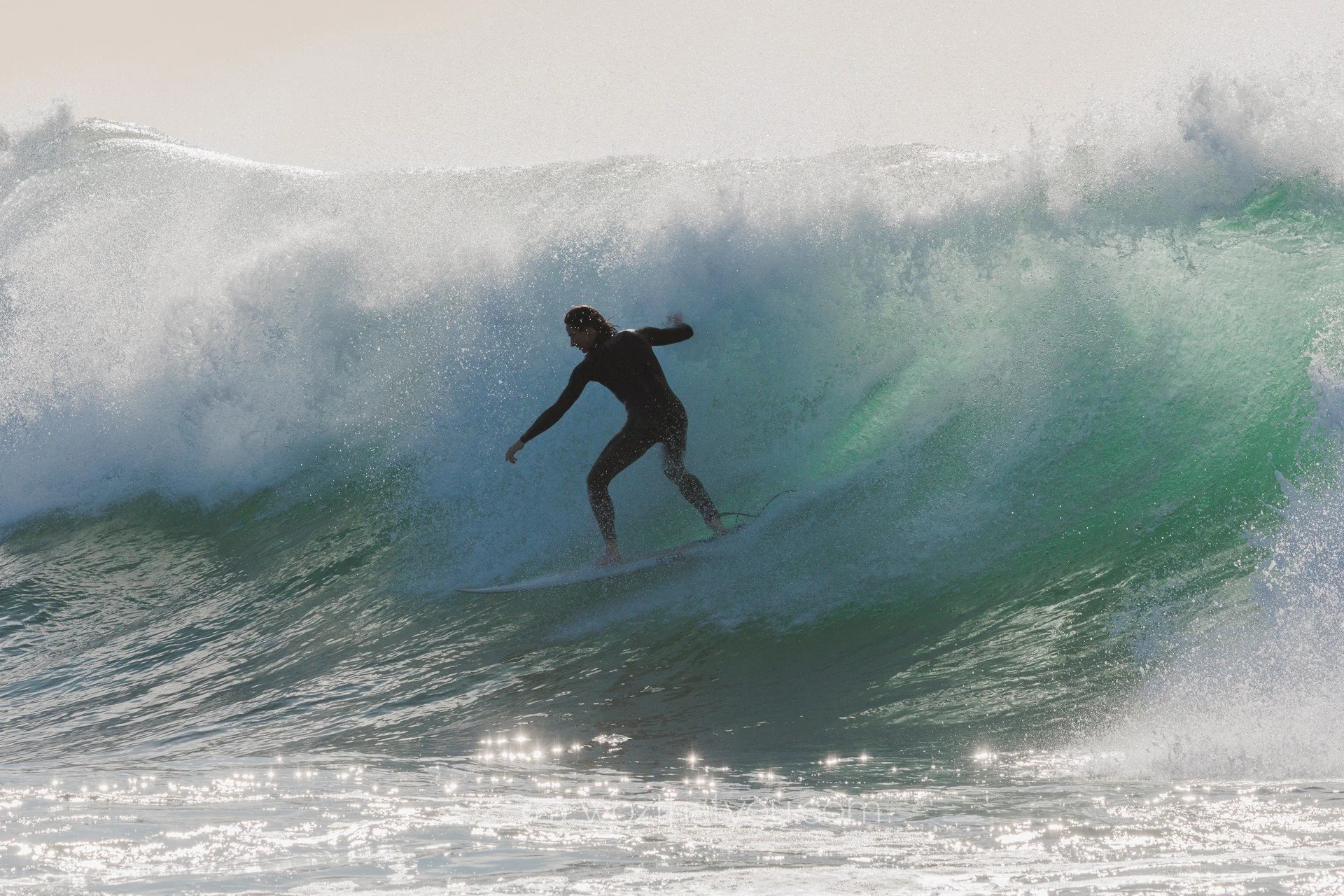 A person surfing on a large ocean wave.