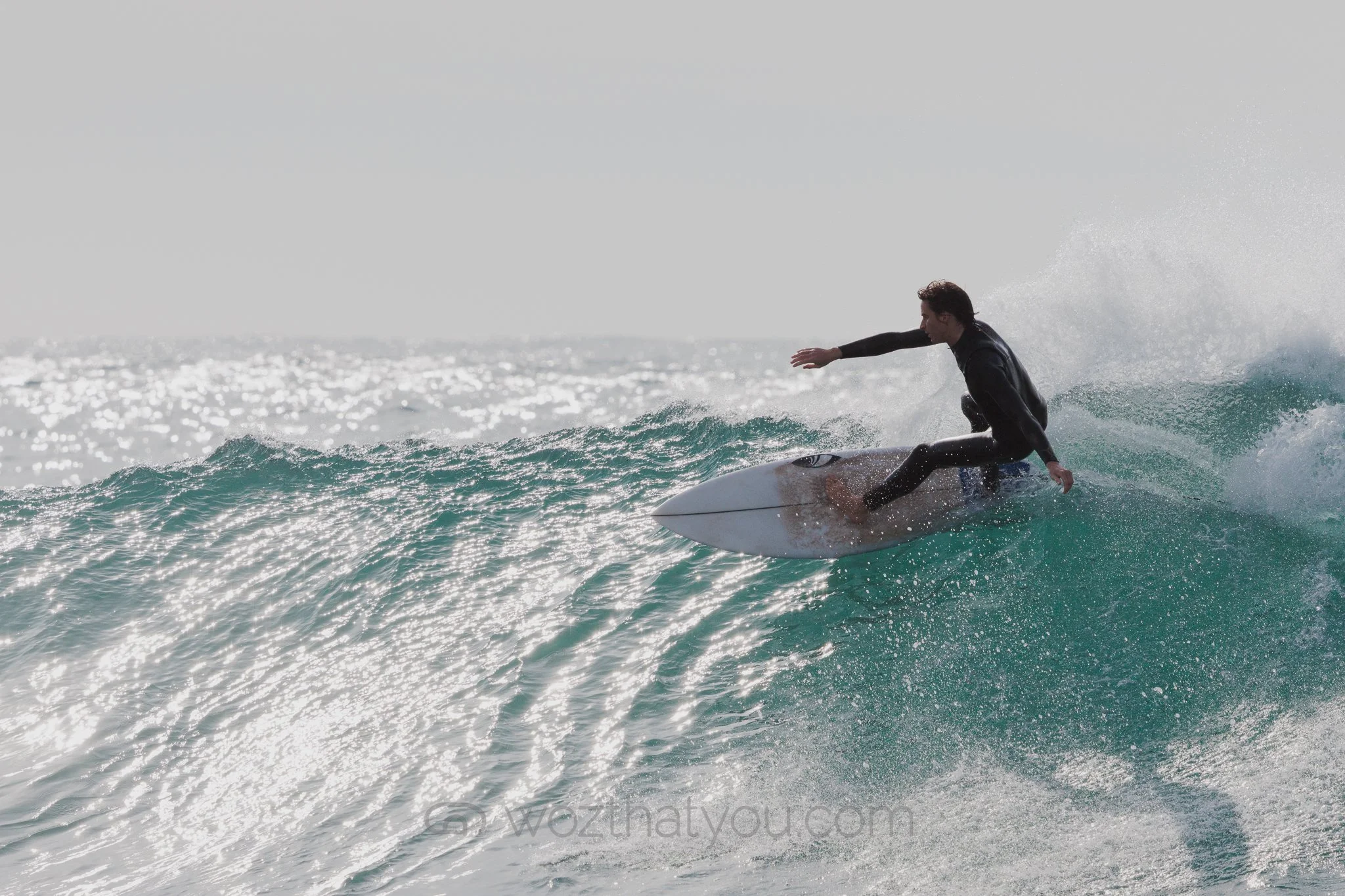 A person surfing on a wave in the ocean during daytime.