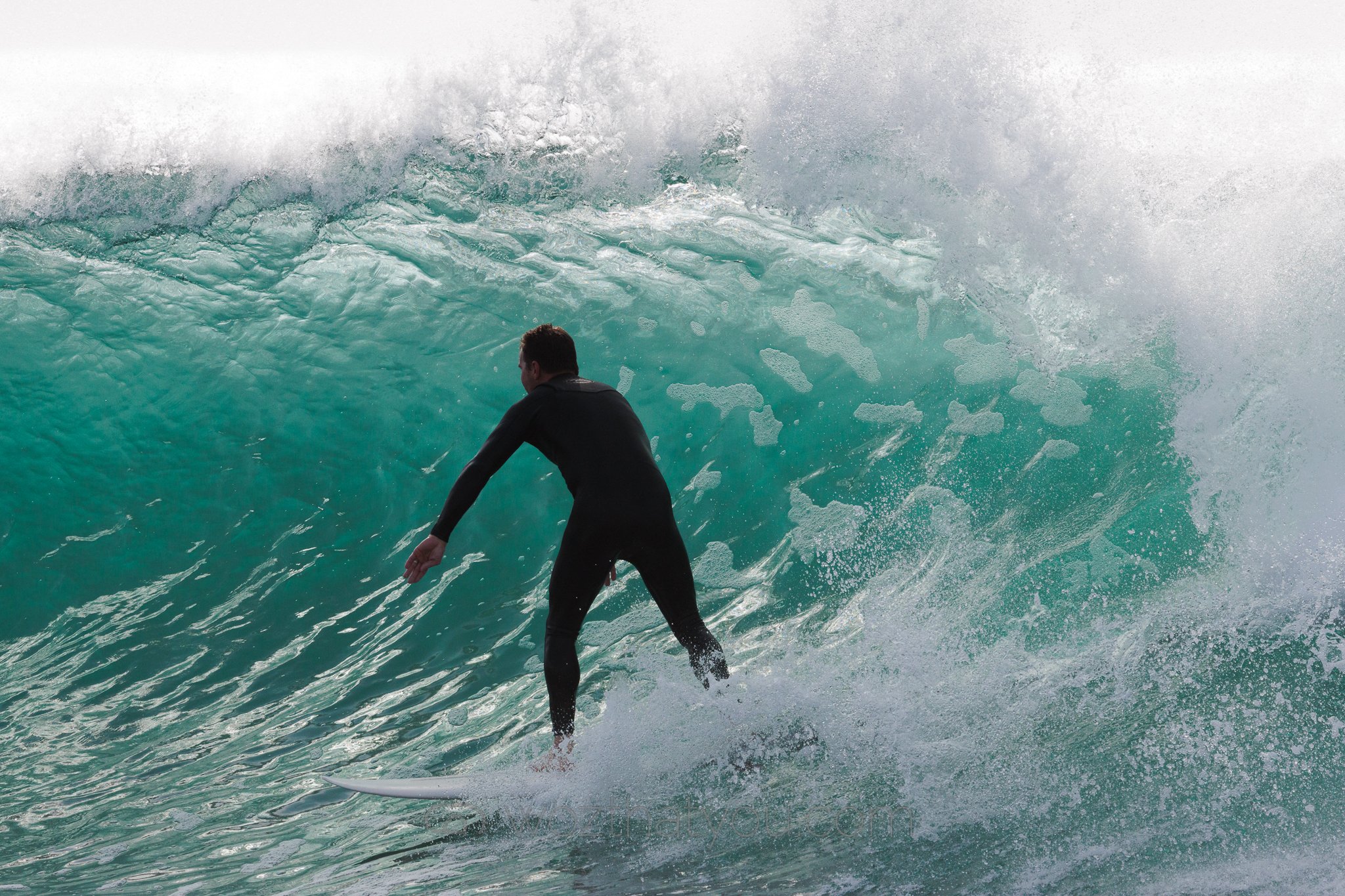 A surfer riding inside the barrel of a large ocean wave.