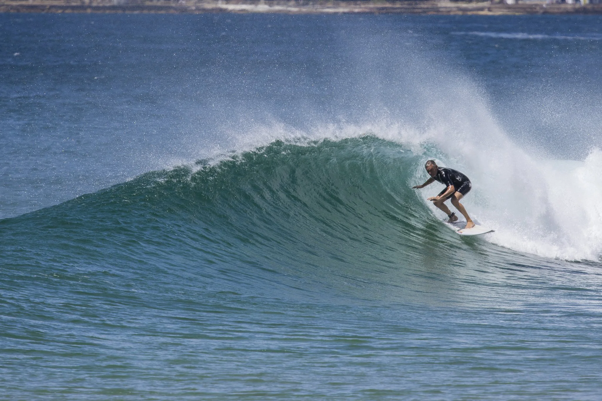 A person surfing on a large wave in the ocean.