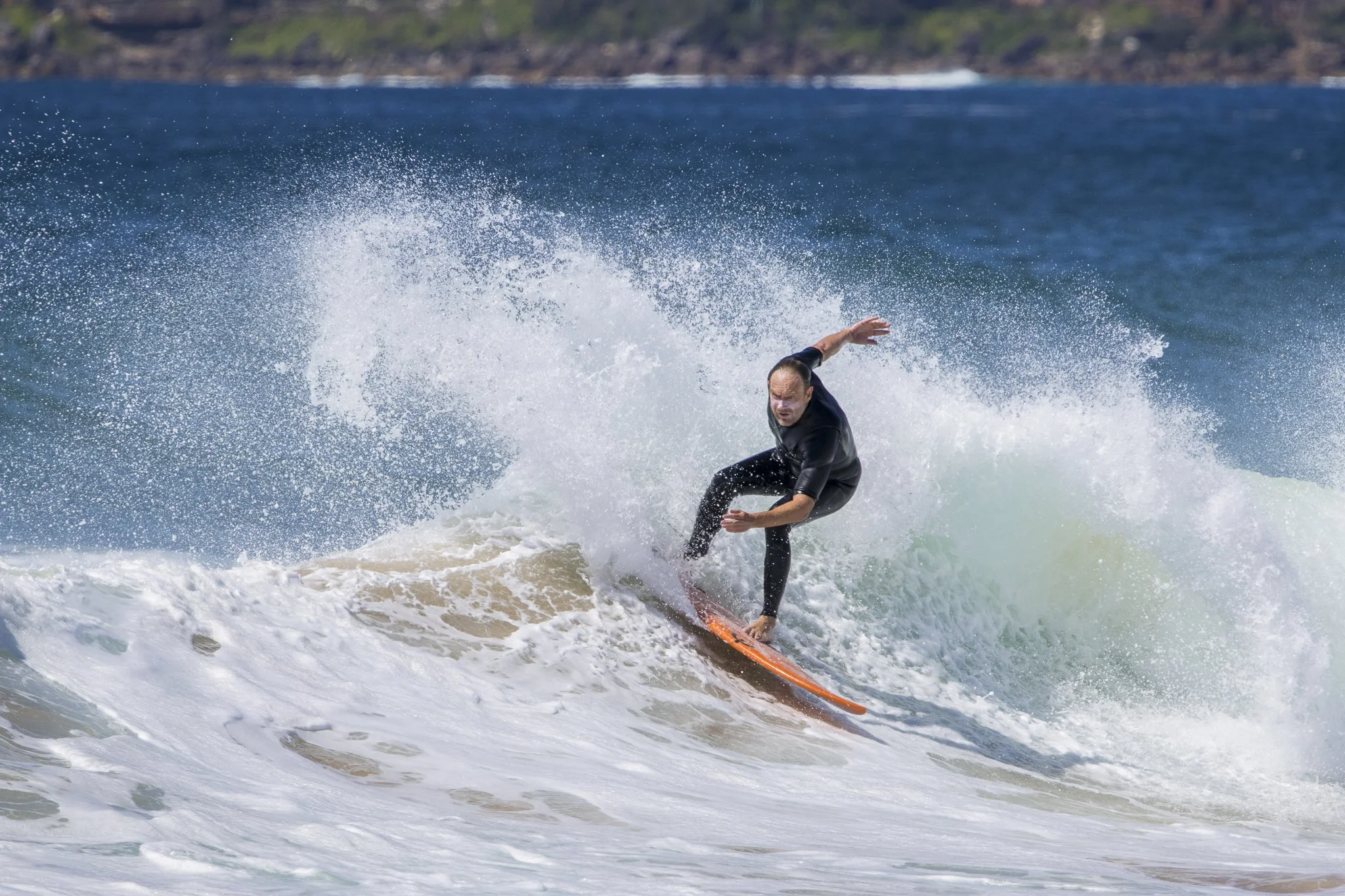 A man surfing on a wave in the ocean.