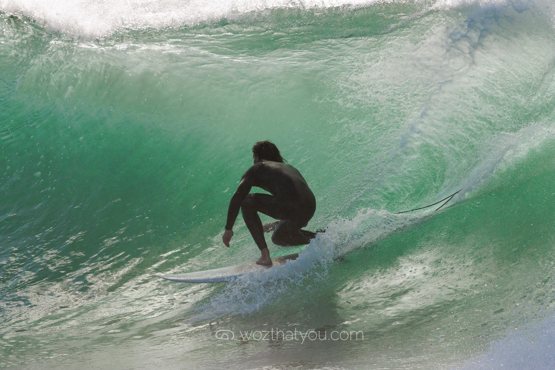 A person surfing on a large ocean wave.