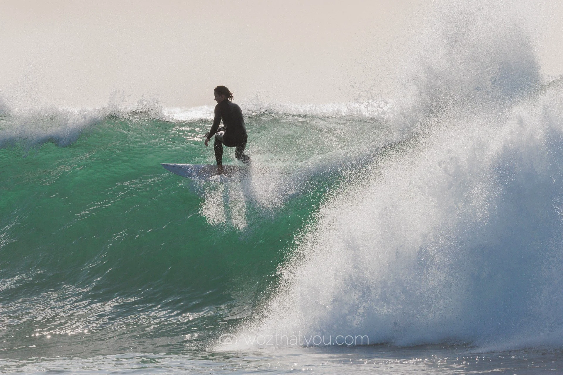 A person surfing on a wave in the ocean during daylight.