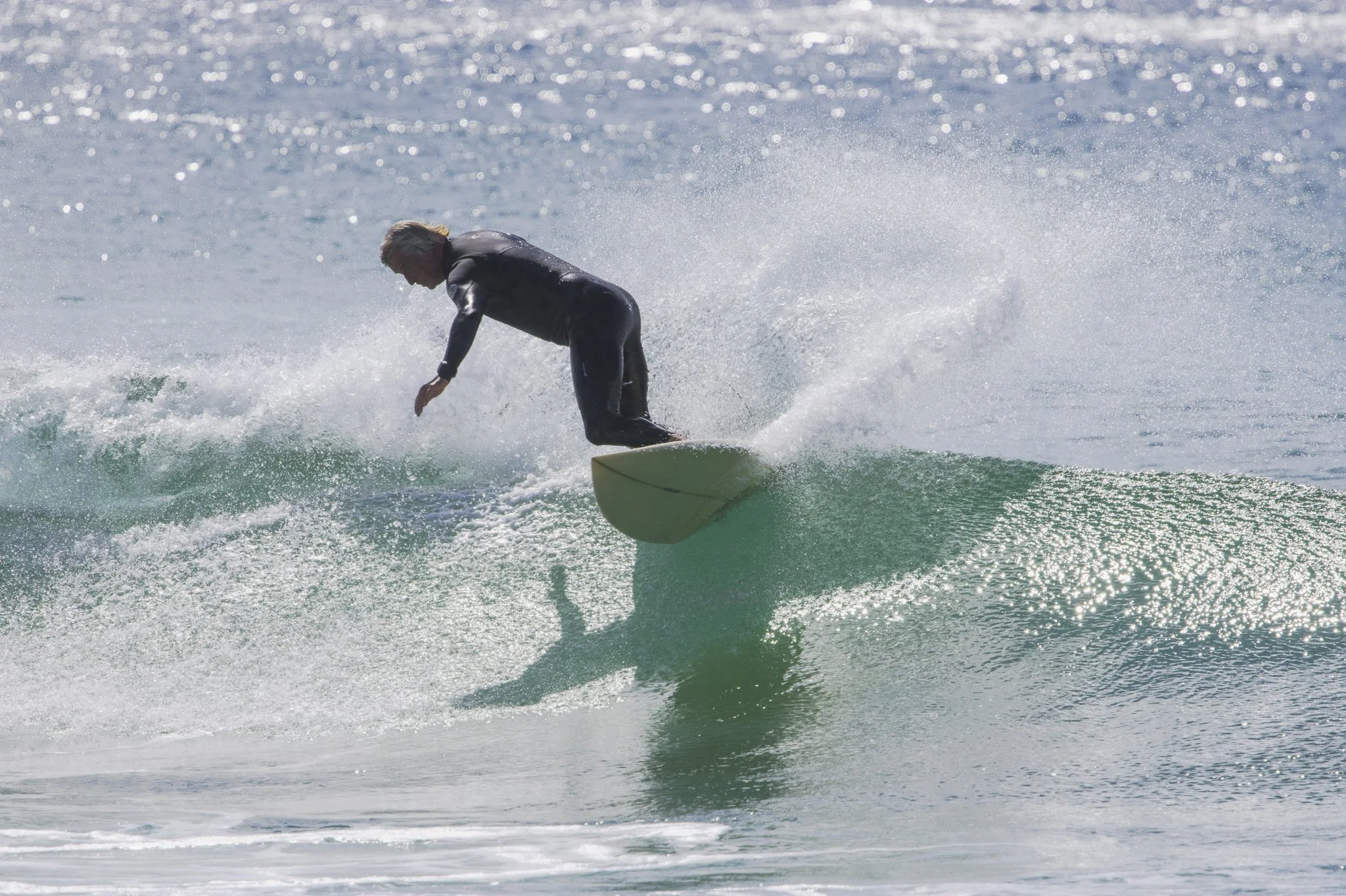 A person surfing on a green wave in the ocean.