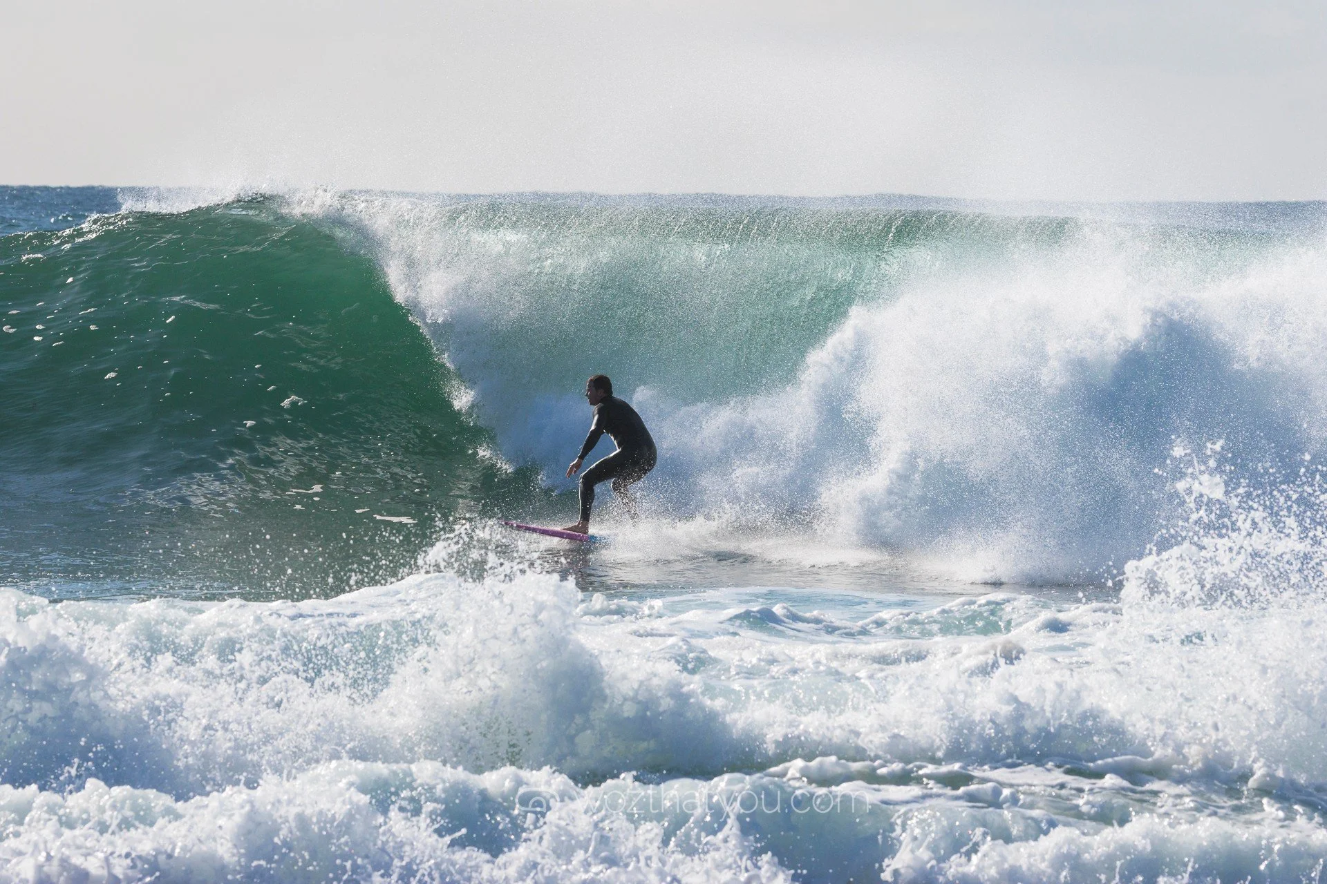 A person surfing on a wave in the ocean during daytime.