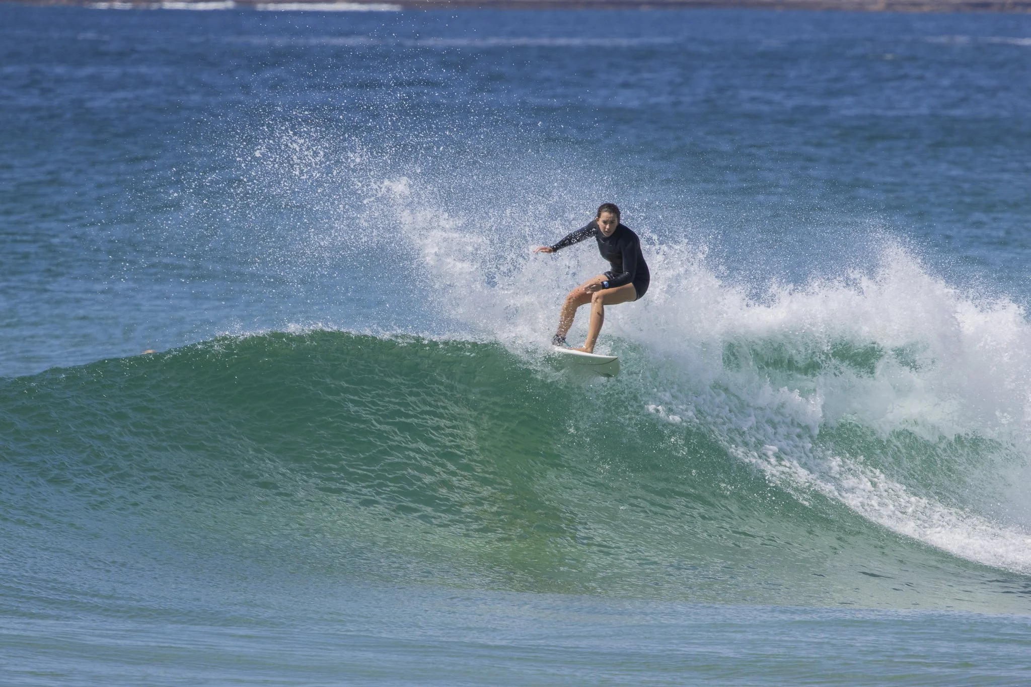 A woman surfing on a wave in the ocean.
