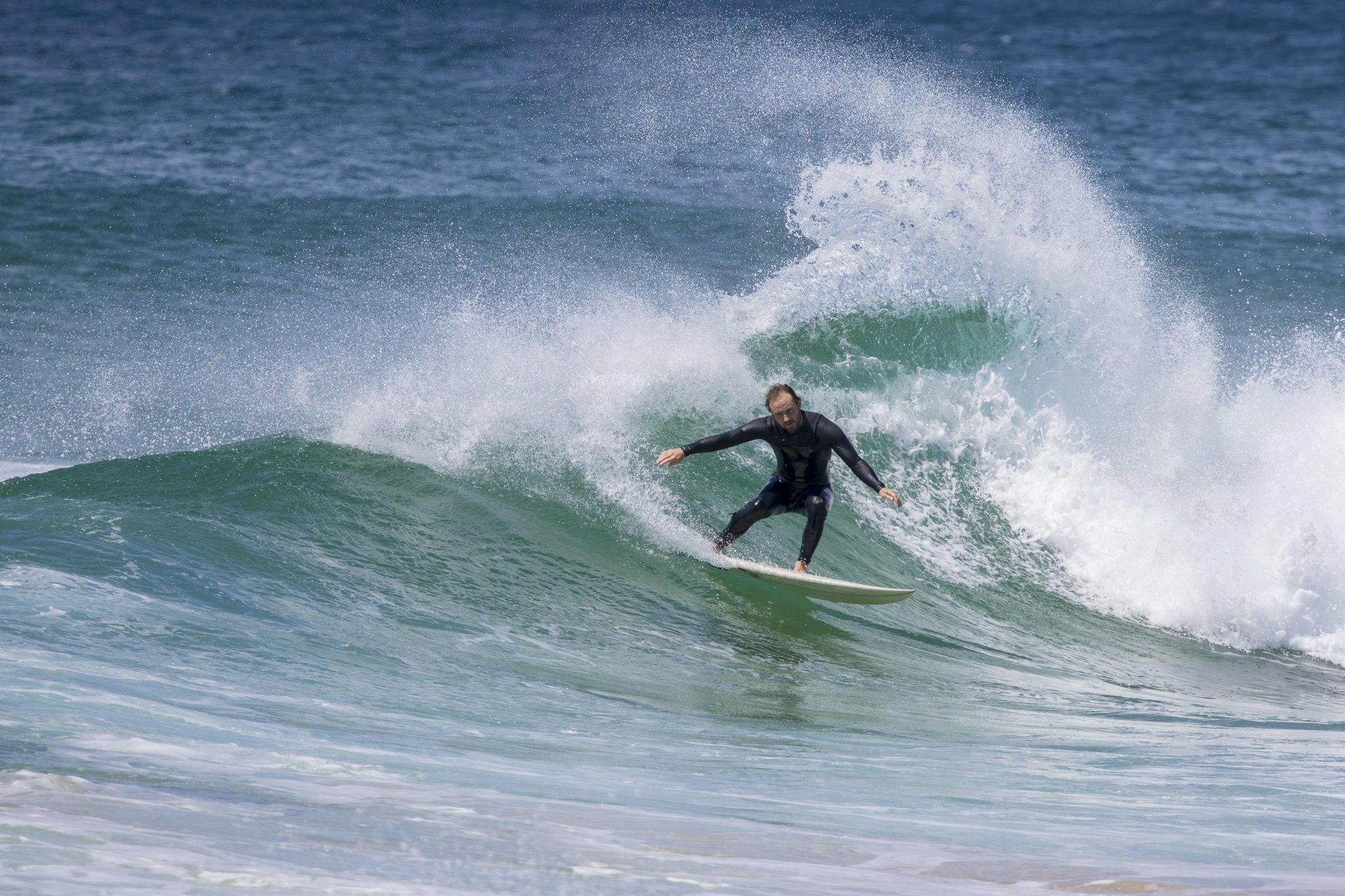 A person surfing on a green wave in the ocean.