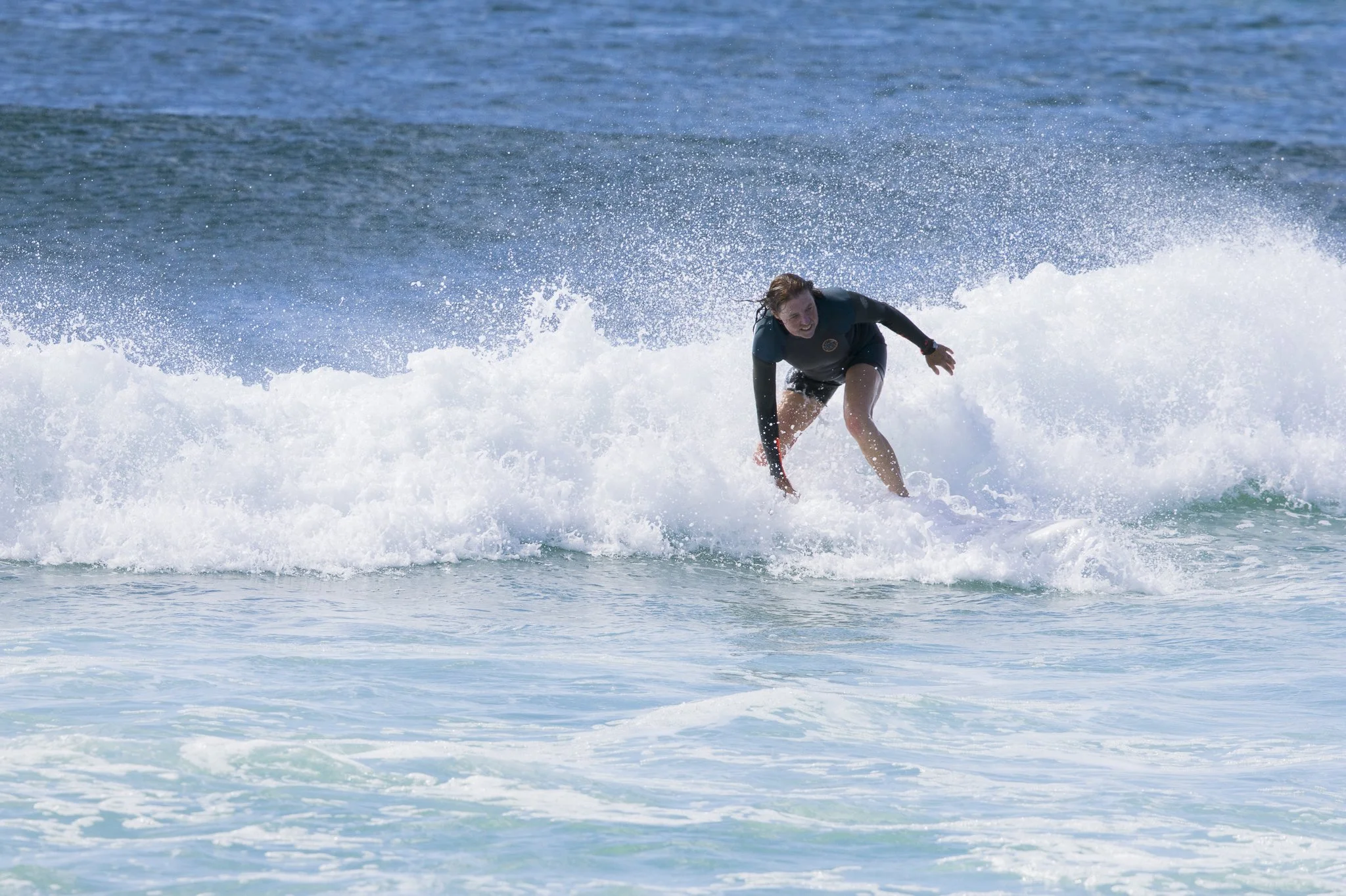 A person surfing on a wave in the ocean.