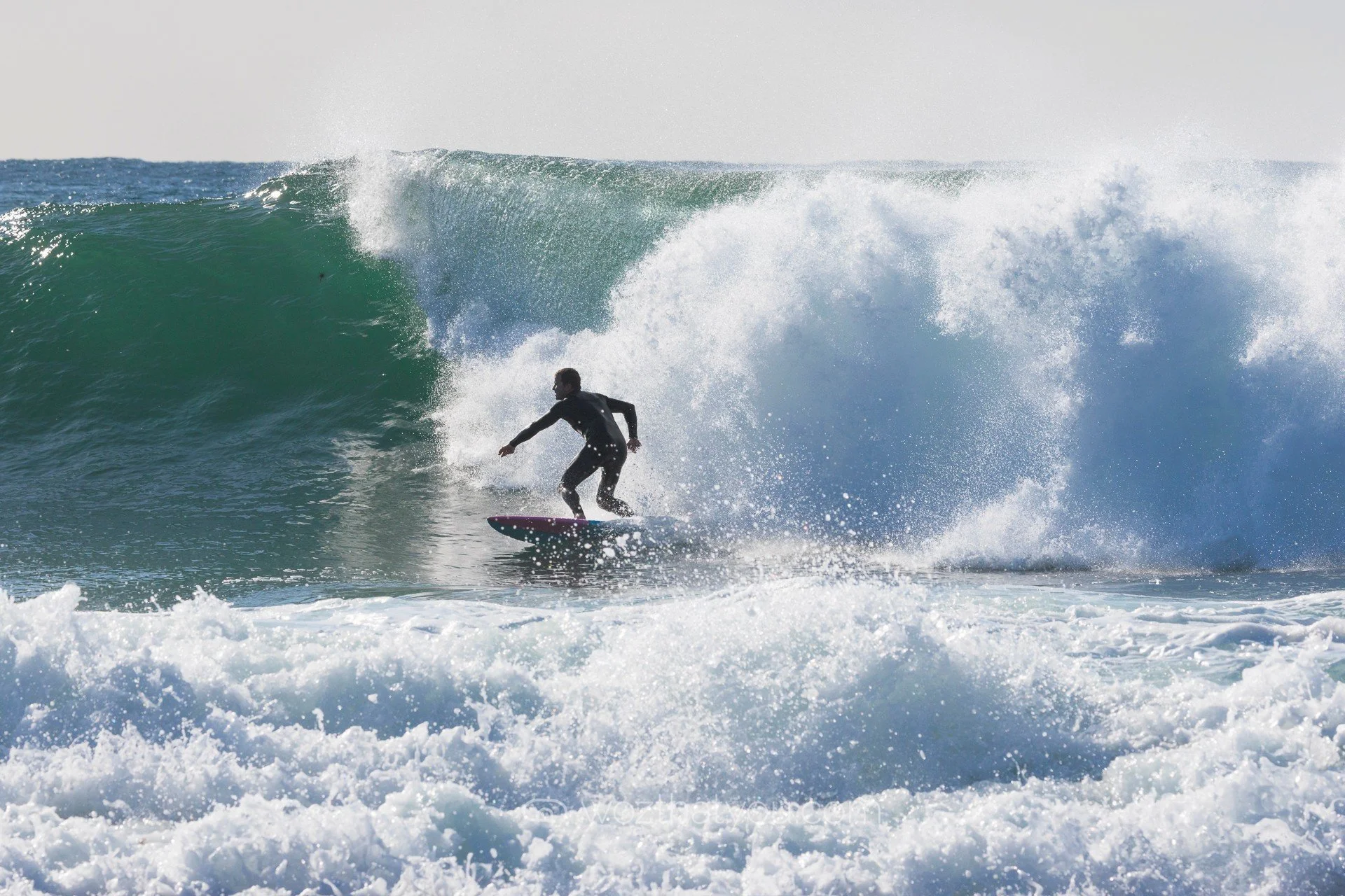 A person surfing on a wave at the beach.