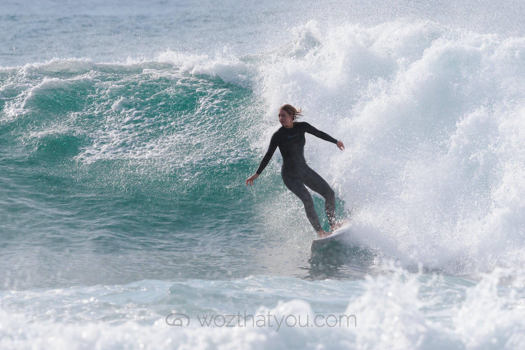 A woman surfing on a wave in the ocean.