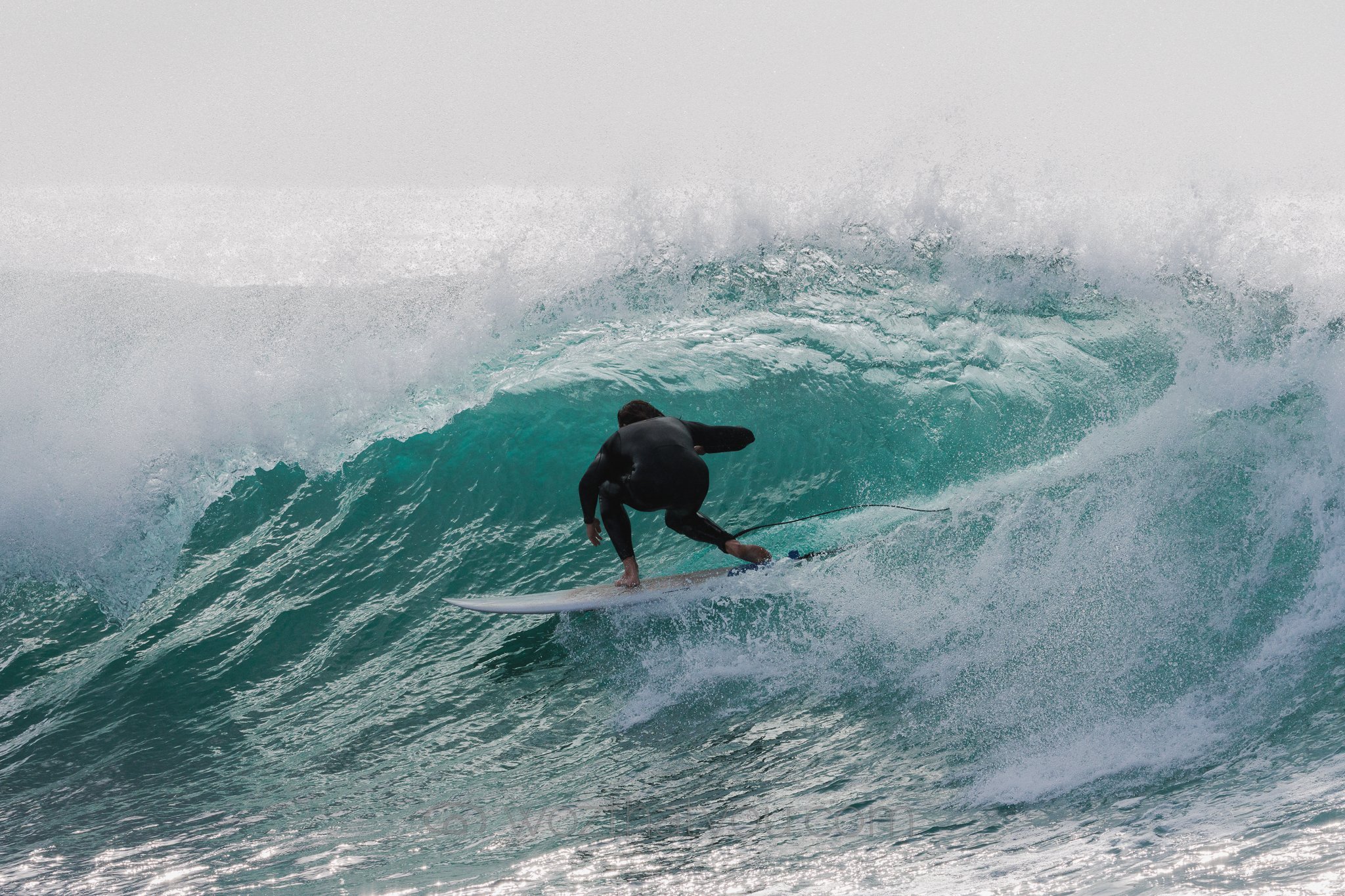 Surfer riding inside a large wave in the ocean.