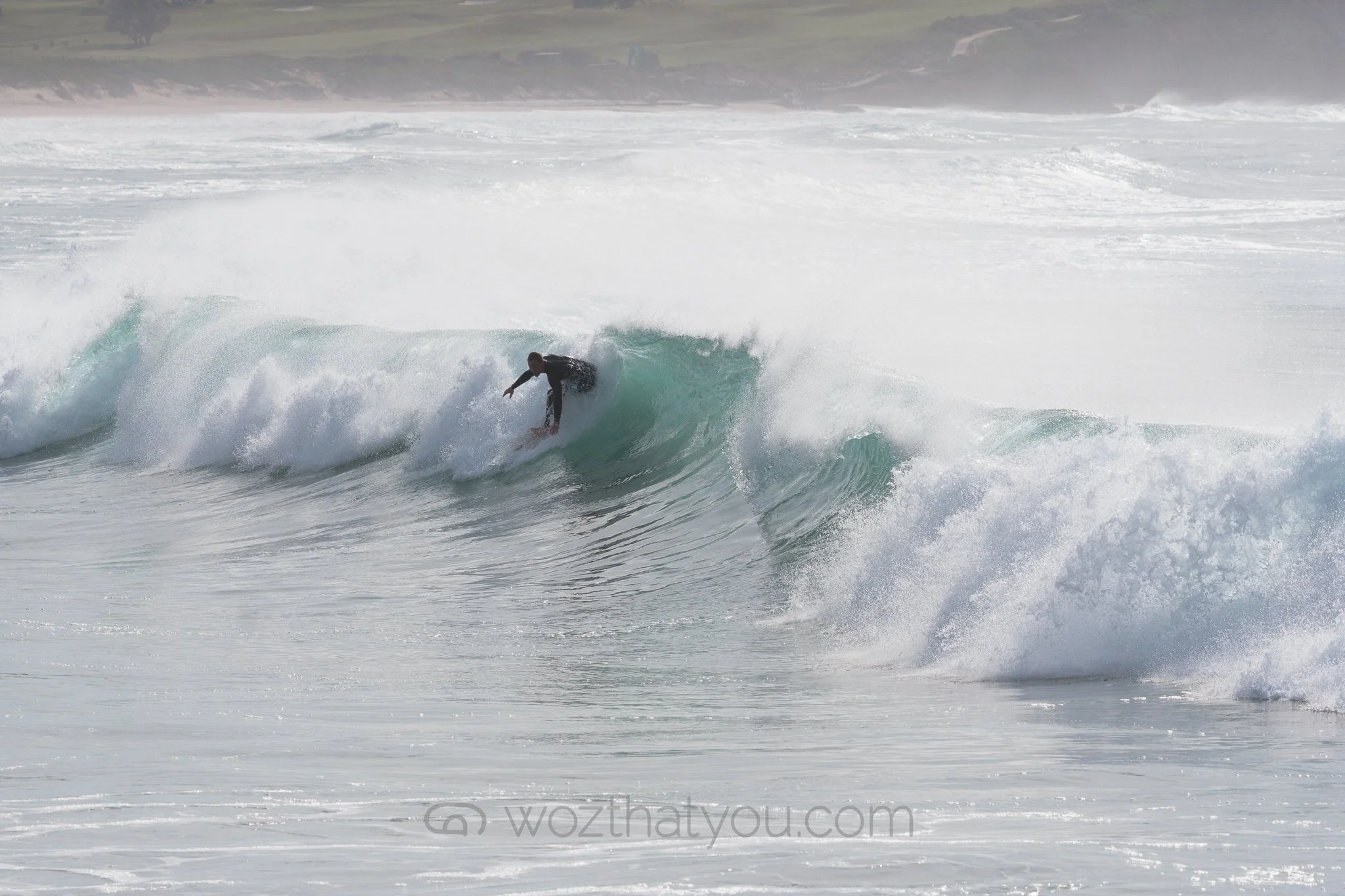 A person surfing on a wave in the ocean.