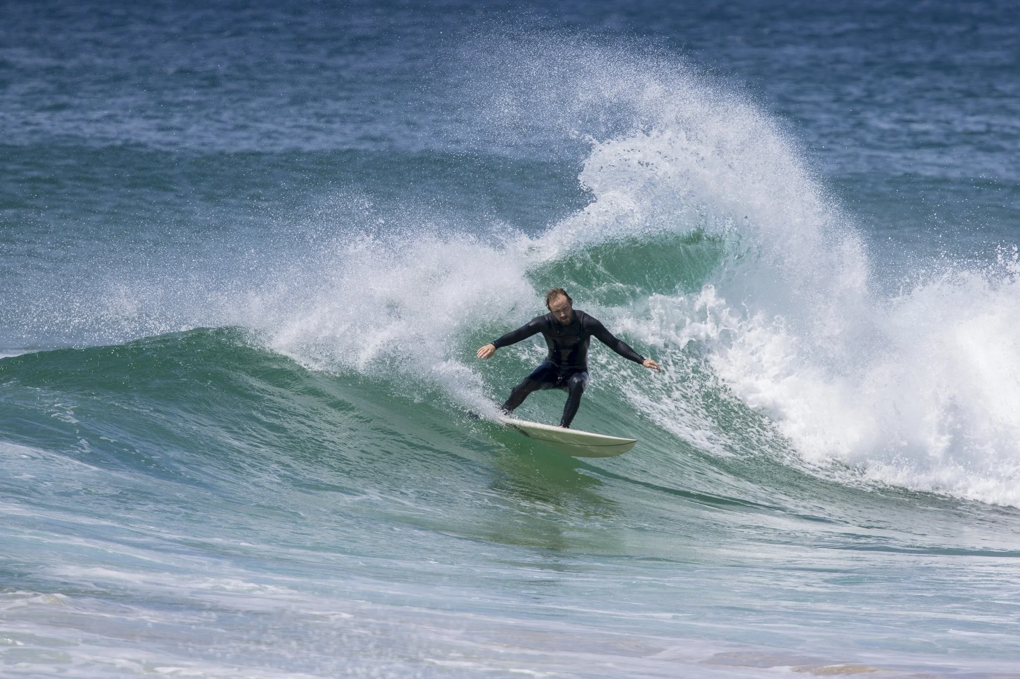 A man surfing on a wave in the ocean.