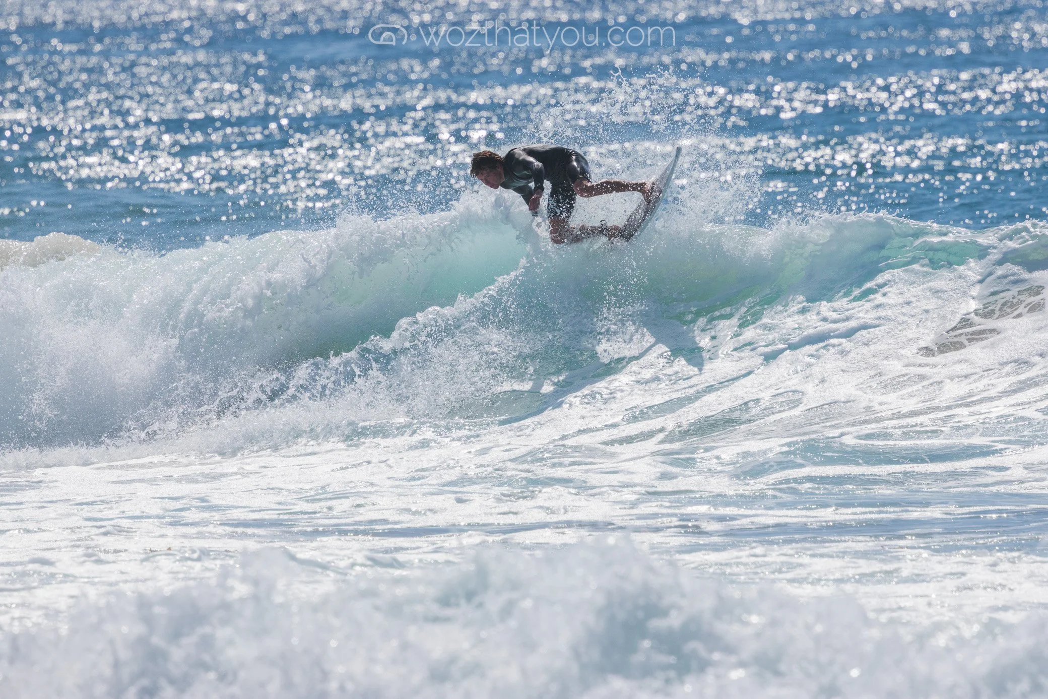 A person surfing on a wave in the ocean during the daytime.