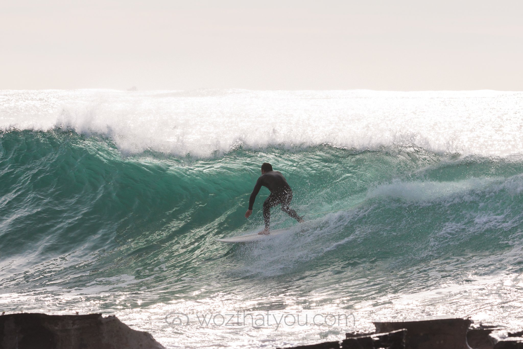 A person surfing on a large ocean wave.
