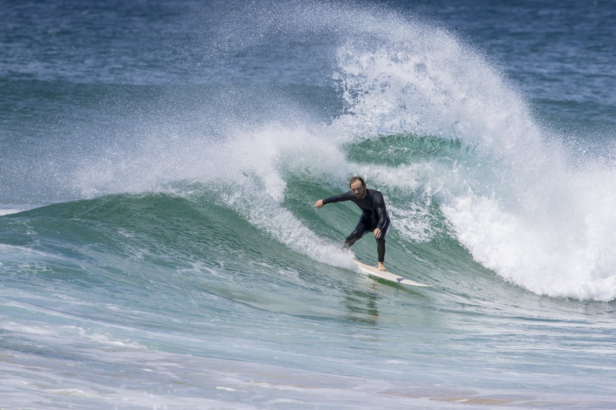 A man surfing on a wave in the ocean.