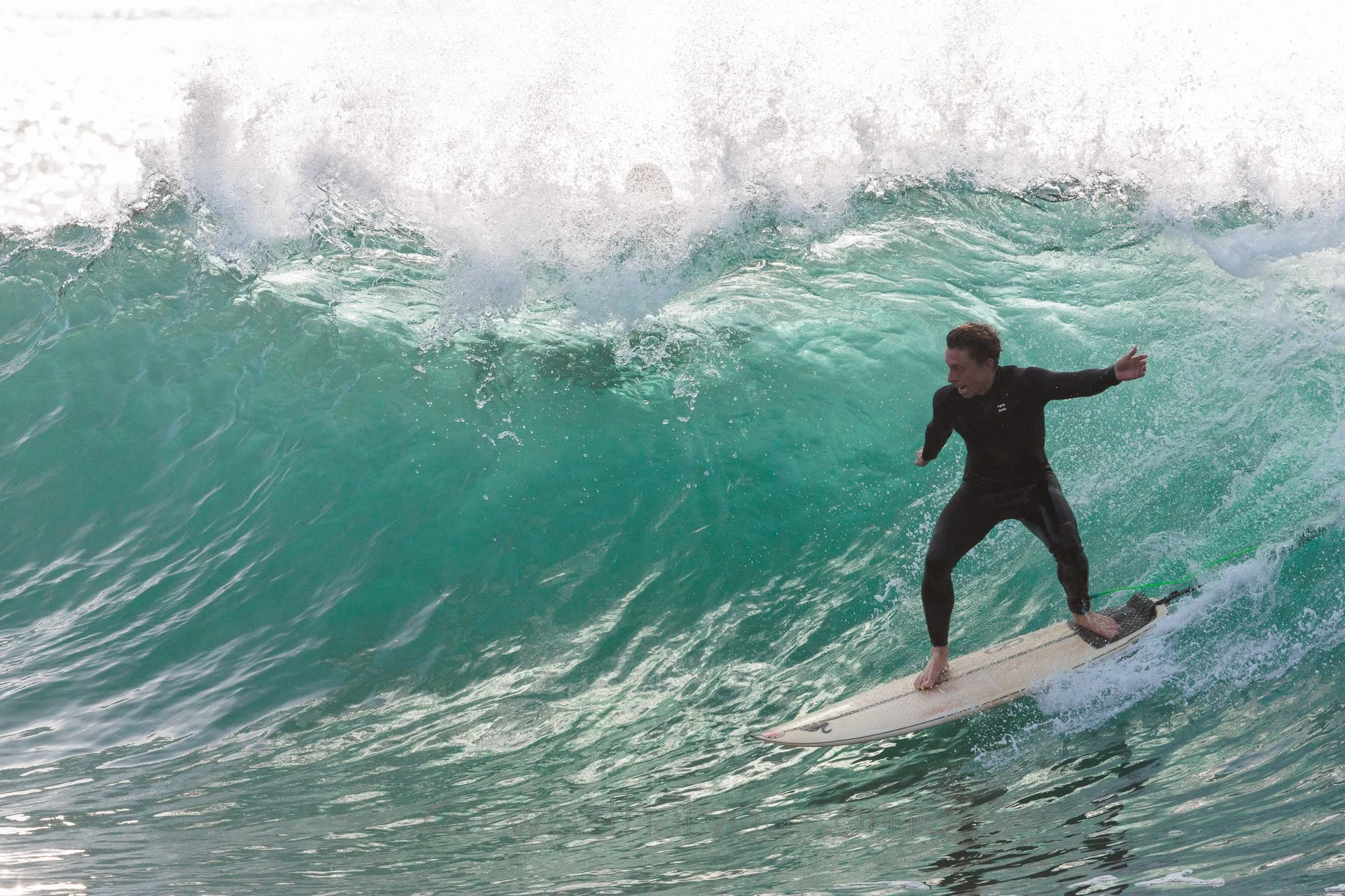 A person surfing on a large ocean wave.