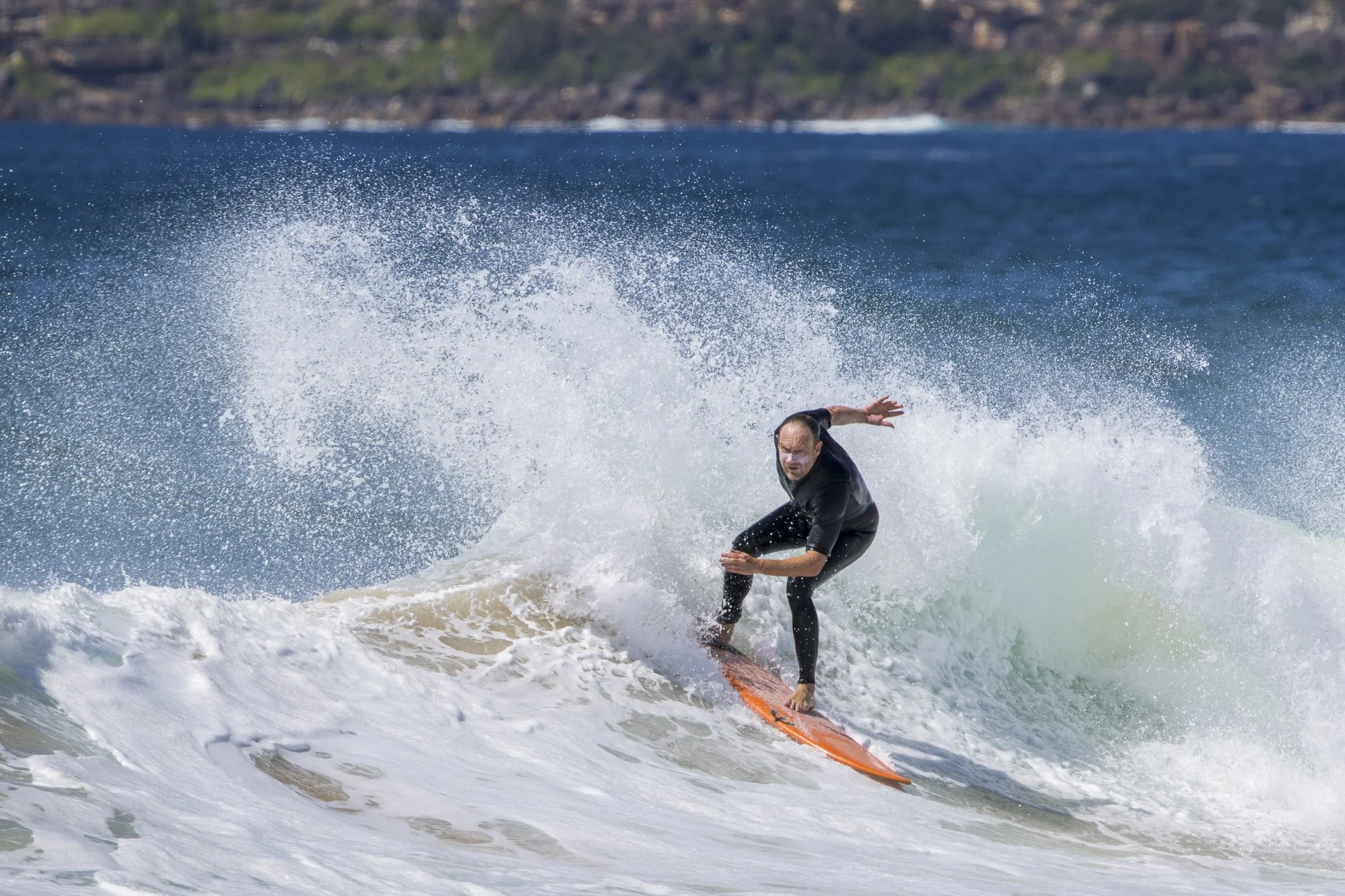 Person surfing on a wave at the beach.
