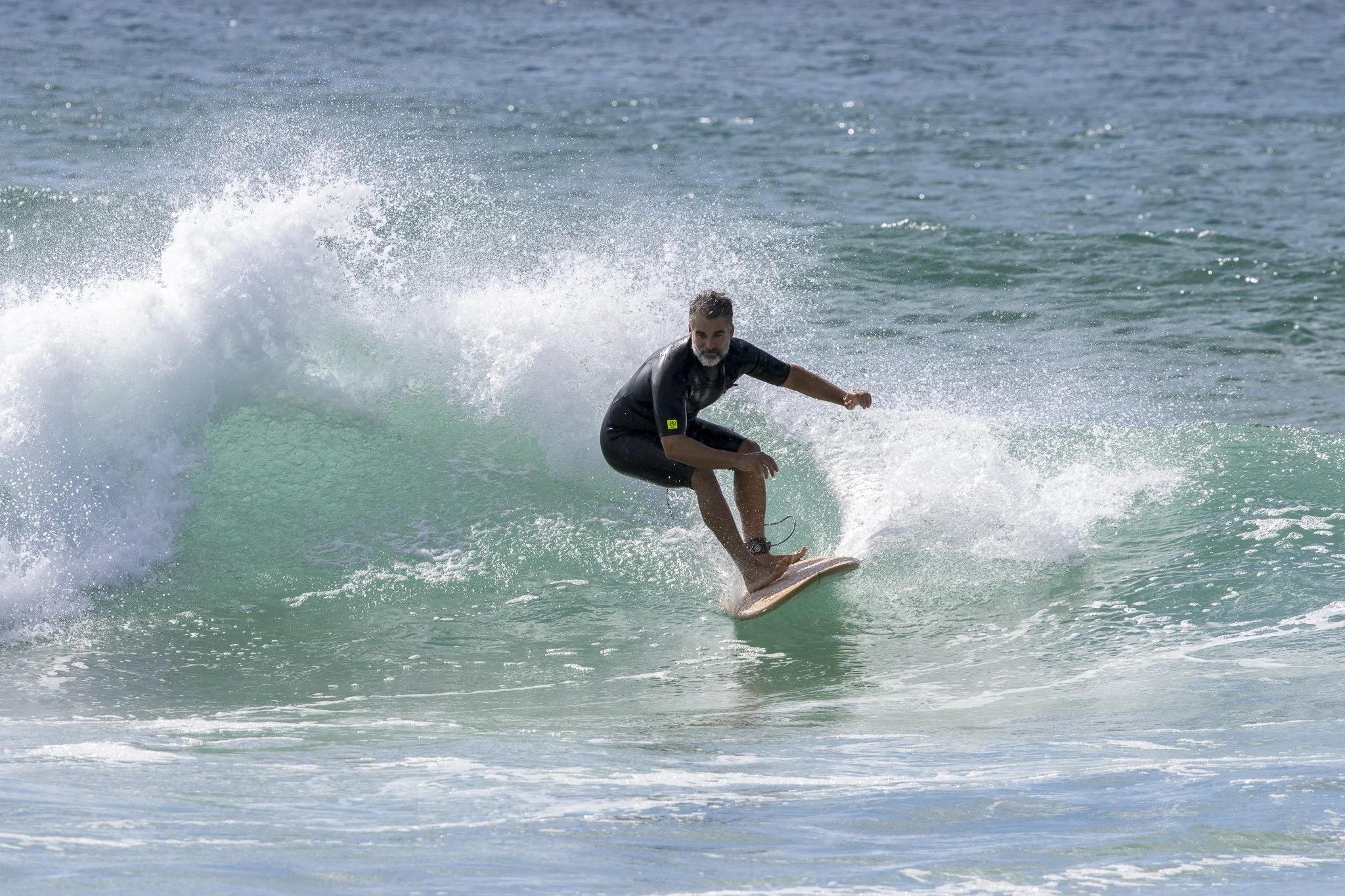 Man surfing on a wave in the ocean.