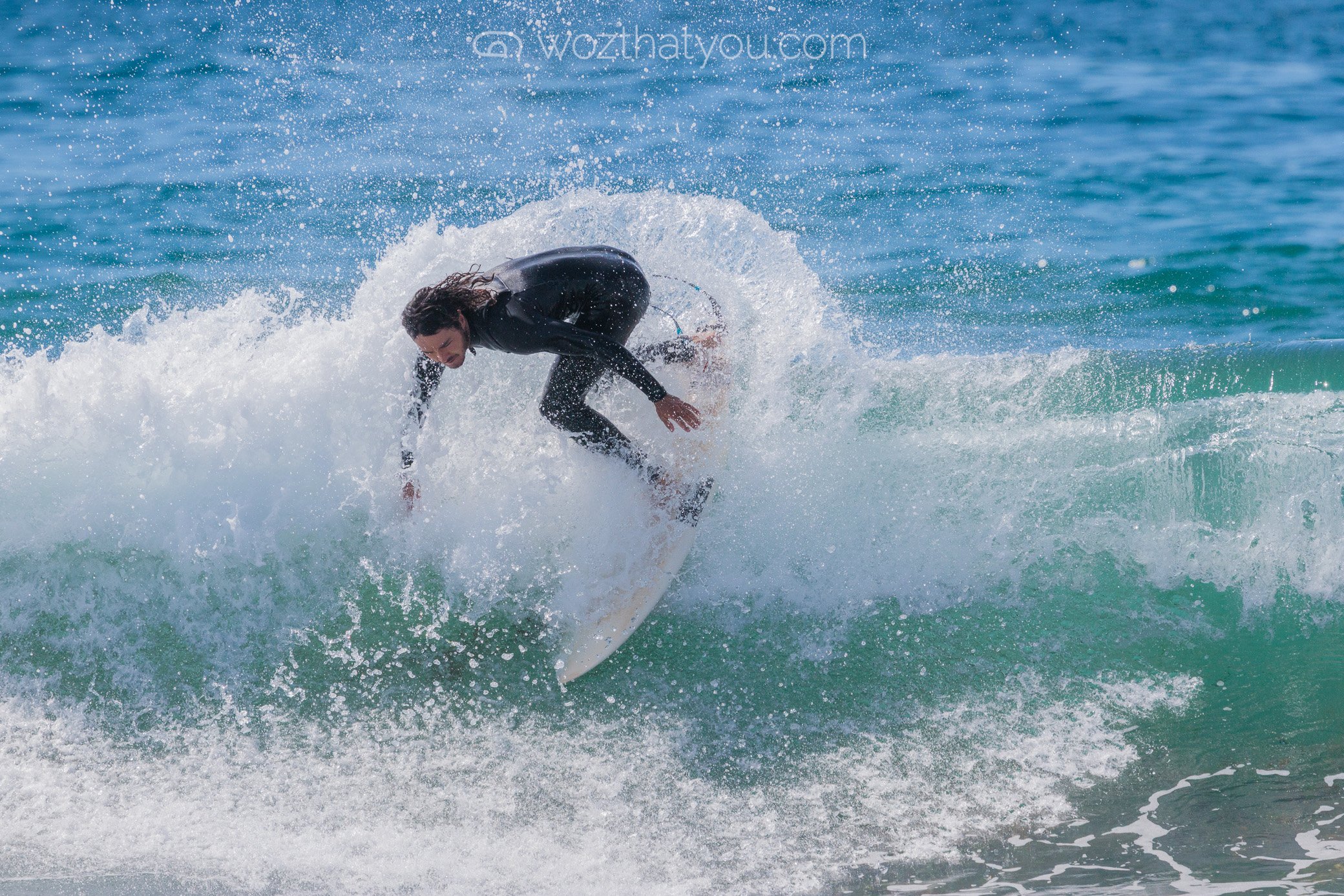 Surfer riding a wave in the ocean with water splashing around.