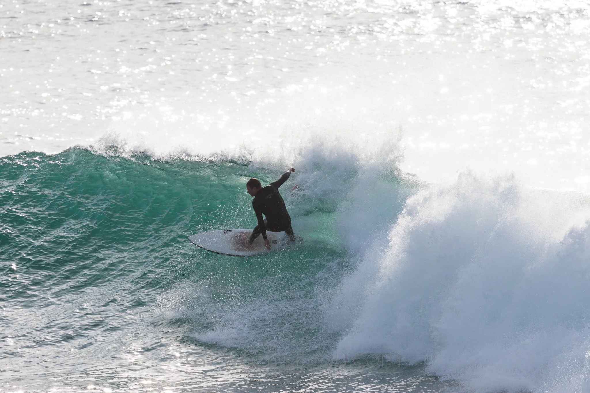 A person surfing on a wave in the ocean during daytime.