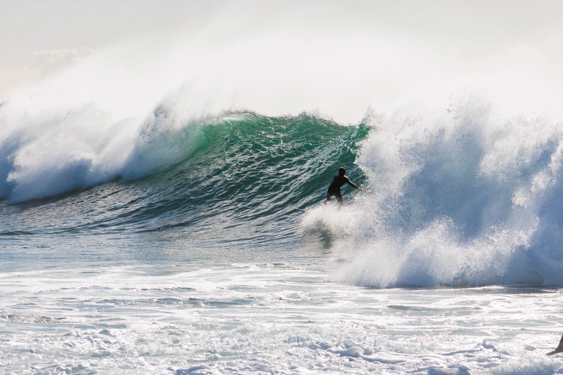 A person surfing on a large wave in the ocean