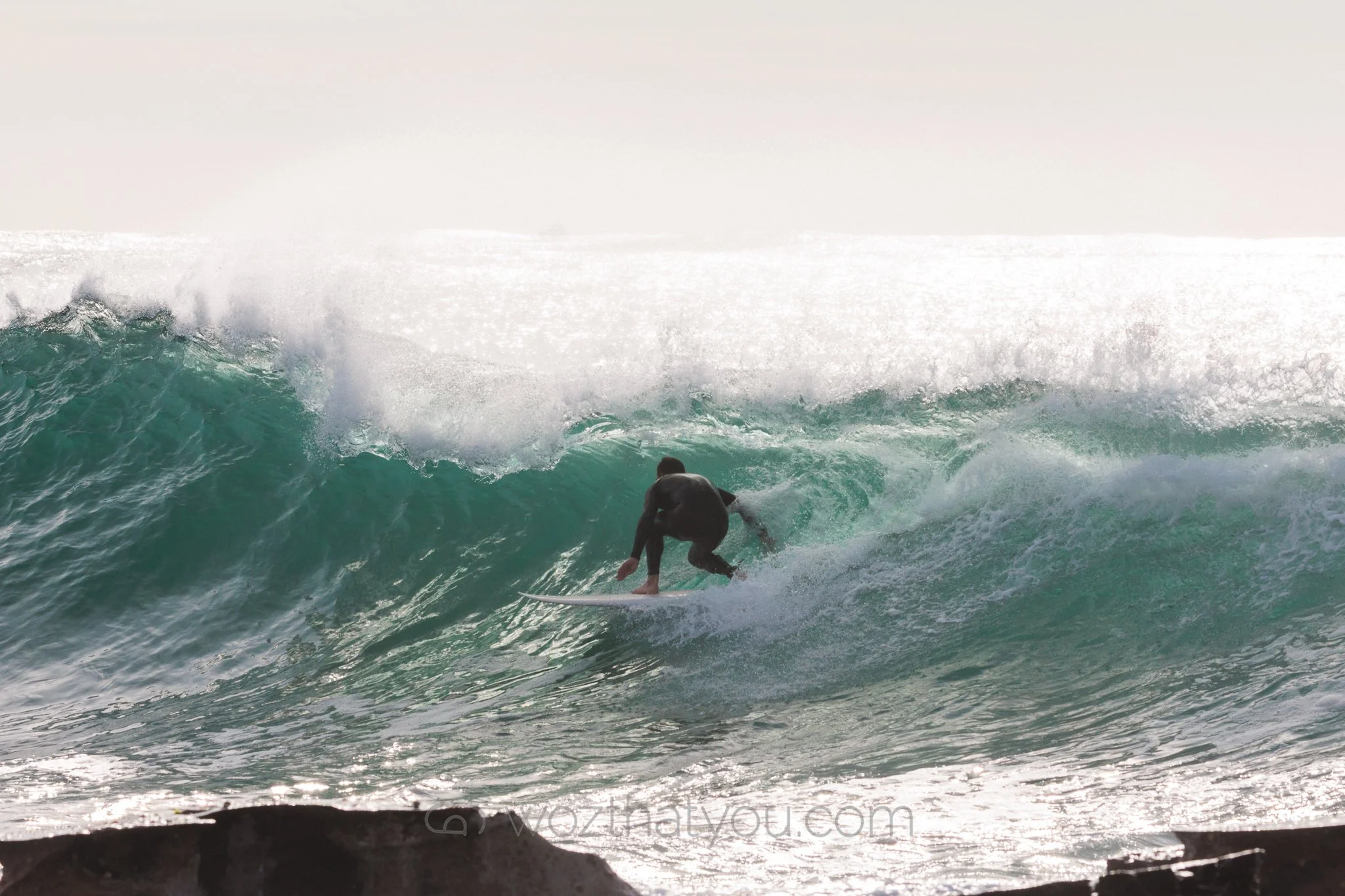 A person surfing on a wave in the ocean during daylight.
