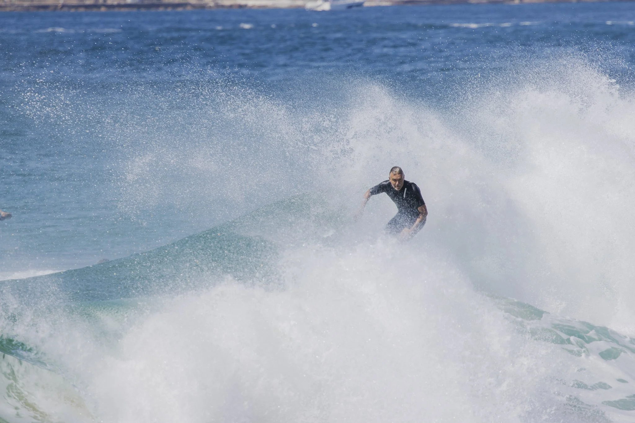 Person surfing on a wave in the ocean.