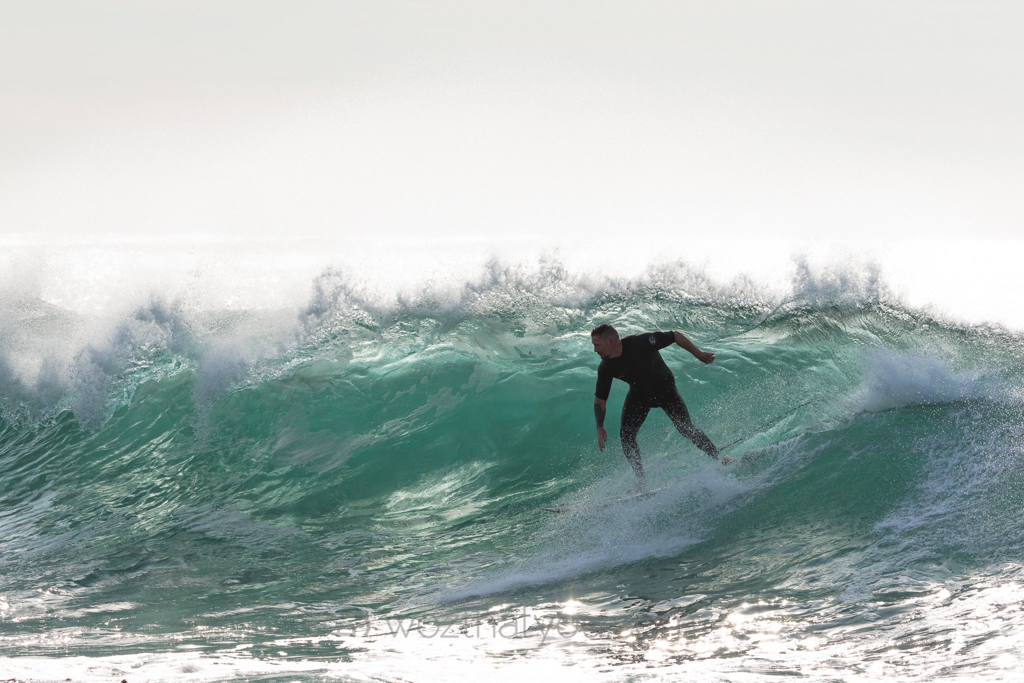 A surfer riding a wave in the ocean during daytime.