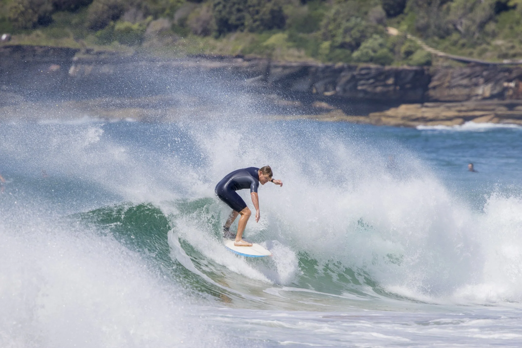 A person surfing on a wave in the ocean.