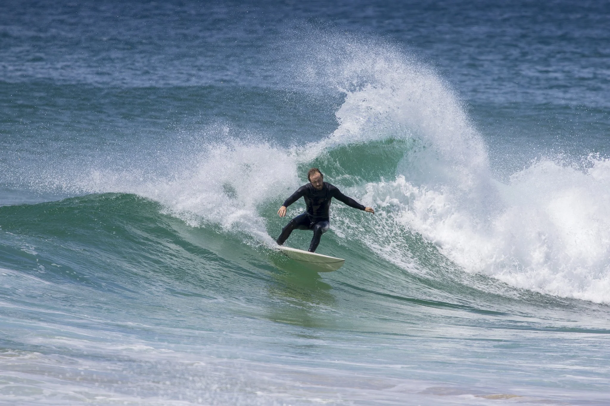 A person surfing on a wave in the ocean.
